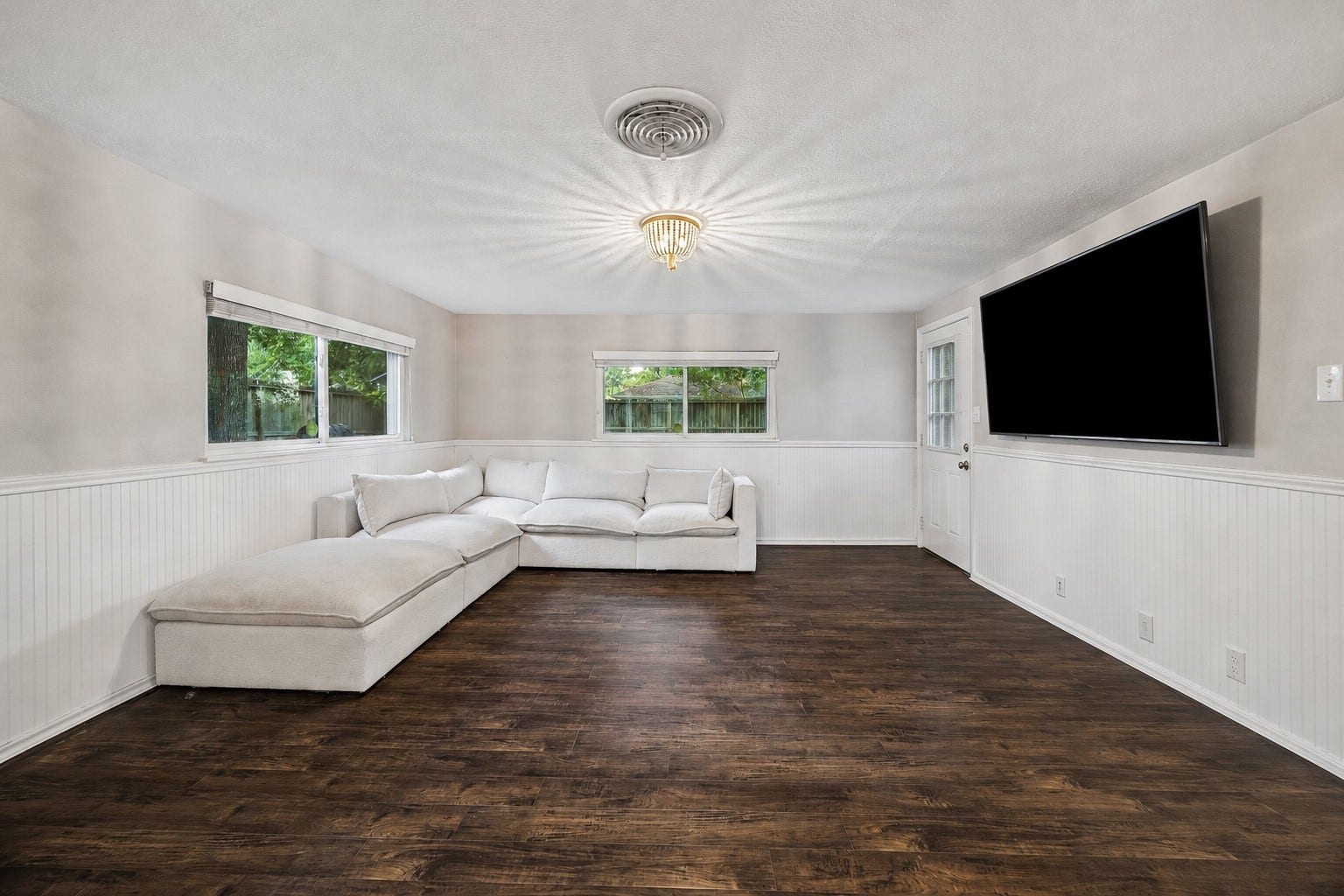 2214 Saxon Drive, Houston, TX 77018 Natural light pours into this spacious family room, offering plenty of room to relax, host movie nights, or gather with friends. Large windows, durable flooring, and direct access to the backyard create an inviting space that blends indoor comfort with outdoor living.