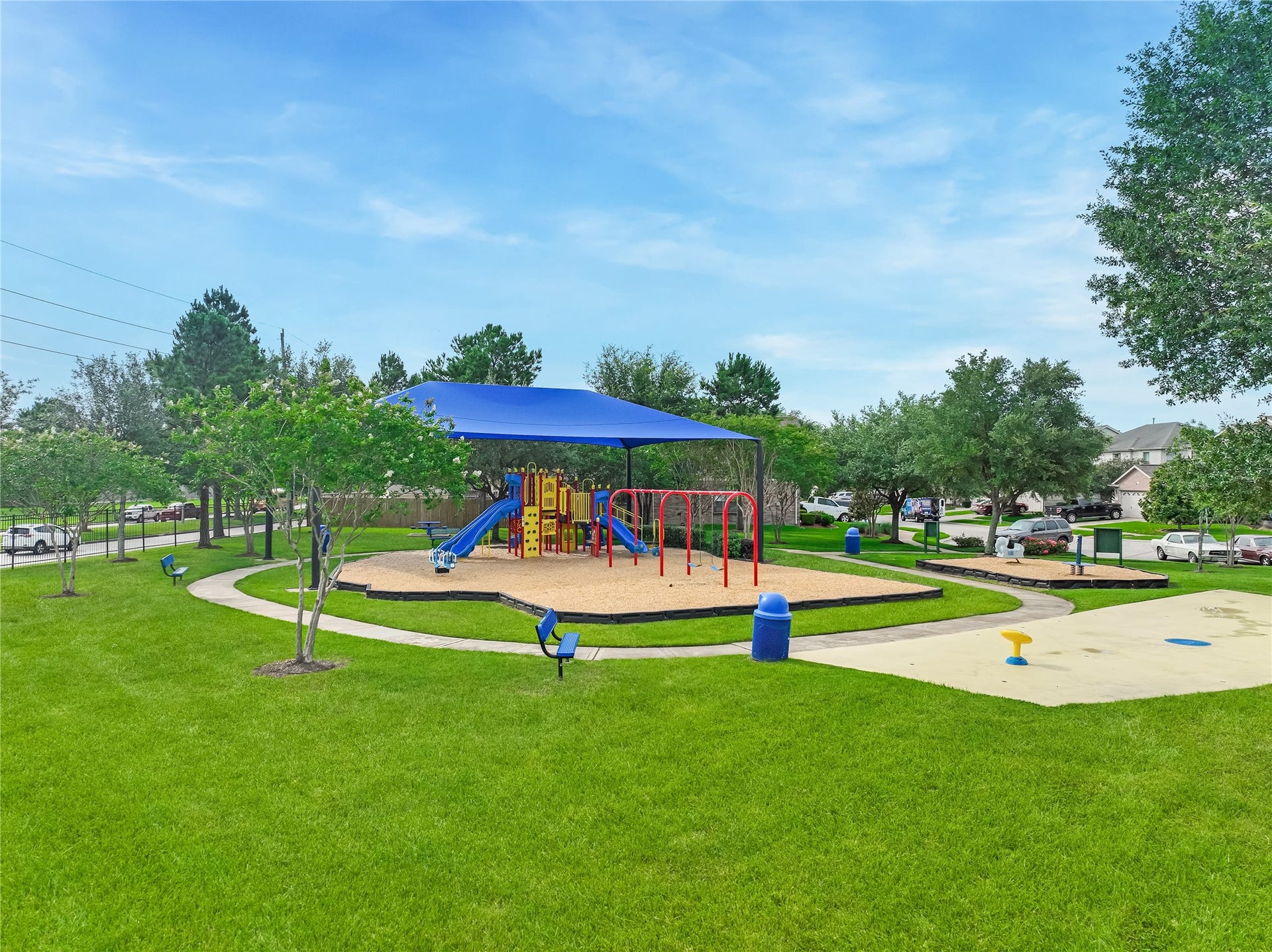 20911 Harvest Terrace Lane, Spring, TX 77379 Wide exterior view of the neighborhood amenities highlighting the playground, splash-pad, and surrounding greenery.