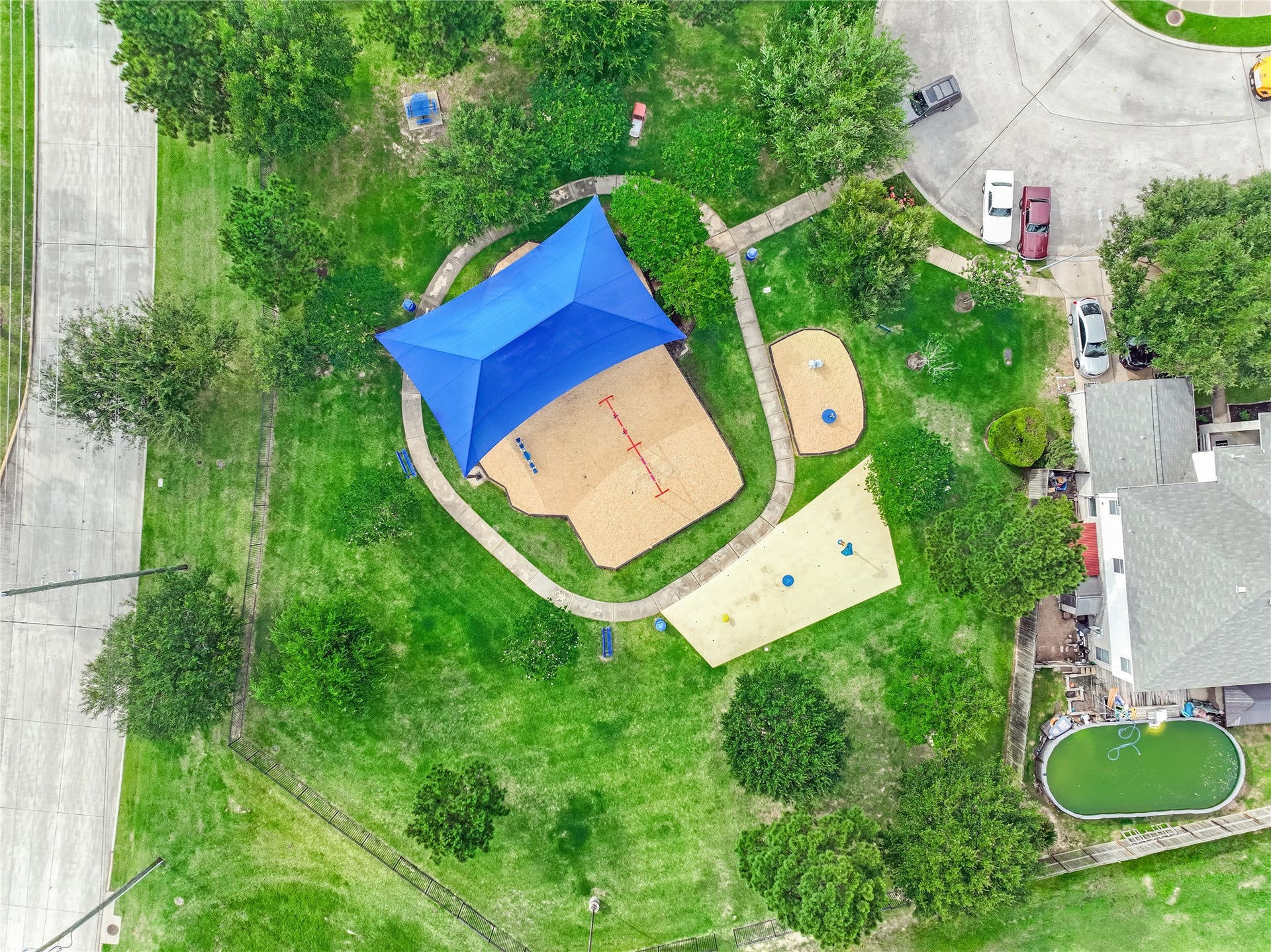 20911 Harvest Terrace Lane, Spring, TX 77379 Drone view of the neighborhood amenities highlighting the playground, and surrounding greenery.