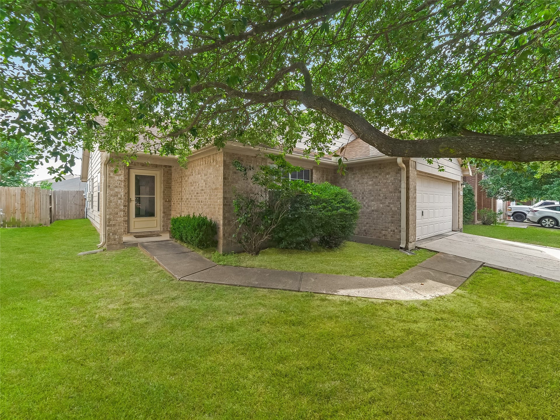 20911 Harvest Terrace Lane, Spring, TX 77379 Exterior view of the home with a covered entryway, mature trees, and a landscaped yard.