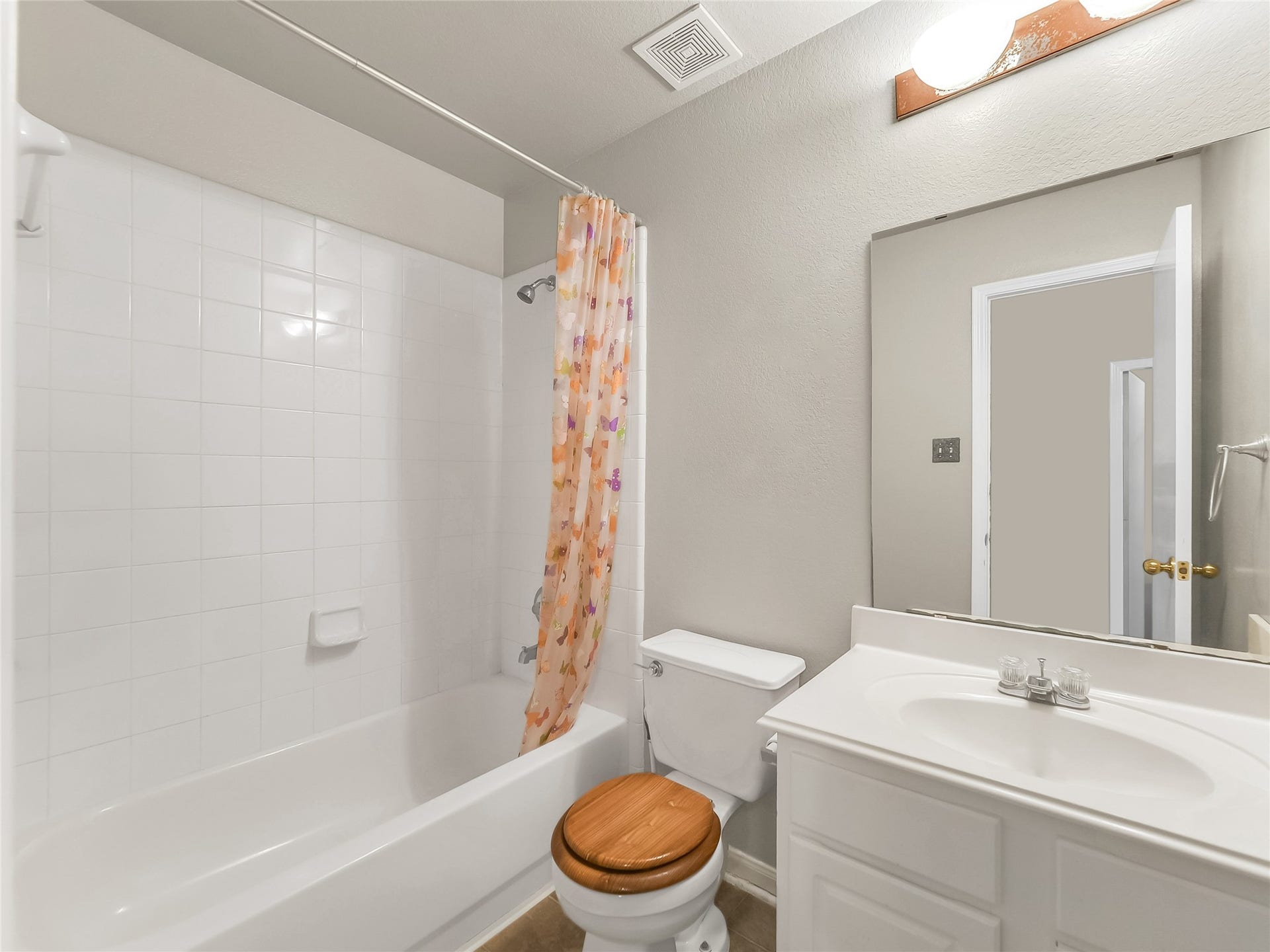20911 Harvest Terrace Lane, Spring, TX 77379 Bathroom with a bathtub and shower combination, tiled walls, and a vanity area.