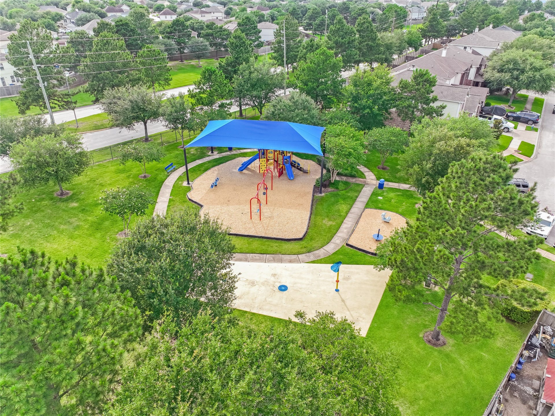 20911 Harvest Terrace Lane, Spring, TX 77379 Drone view of the neighborhood amenities highlighting the playground, and surrounding greenery.