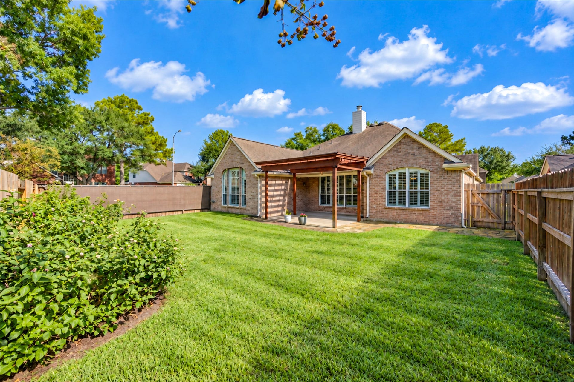 Room for outdoor activities, this backyard is well manicured and loved.  The pergola extends the covered patio for the days when more shade is needed.