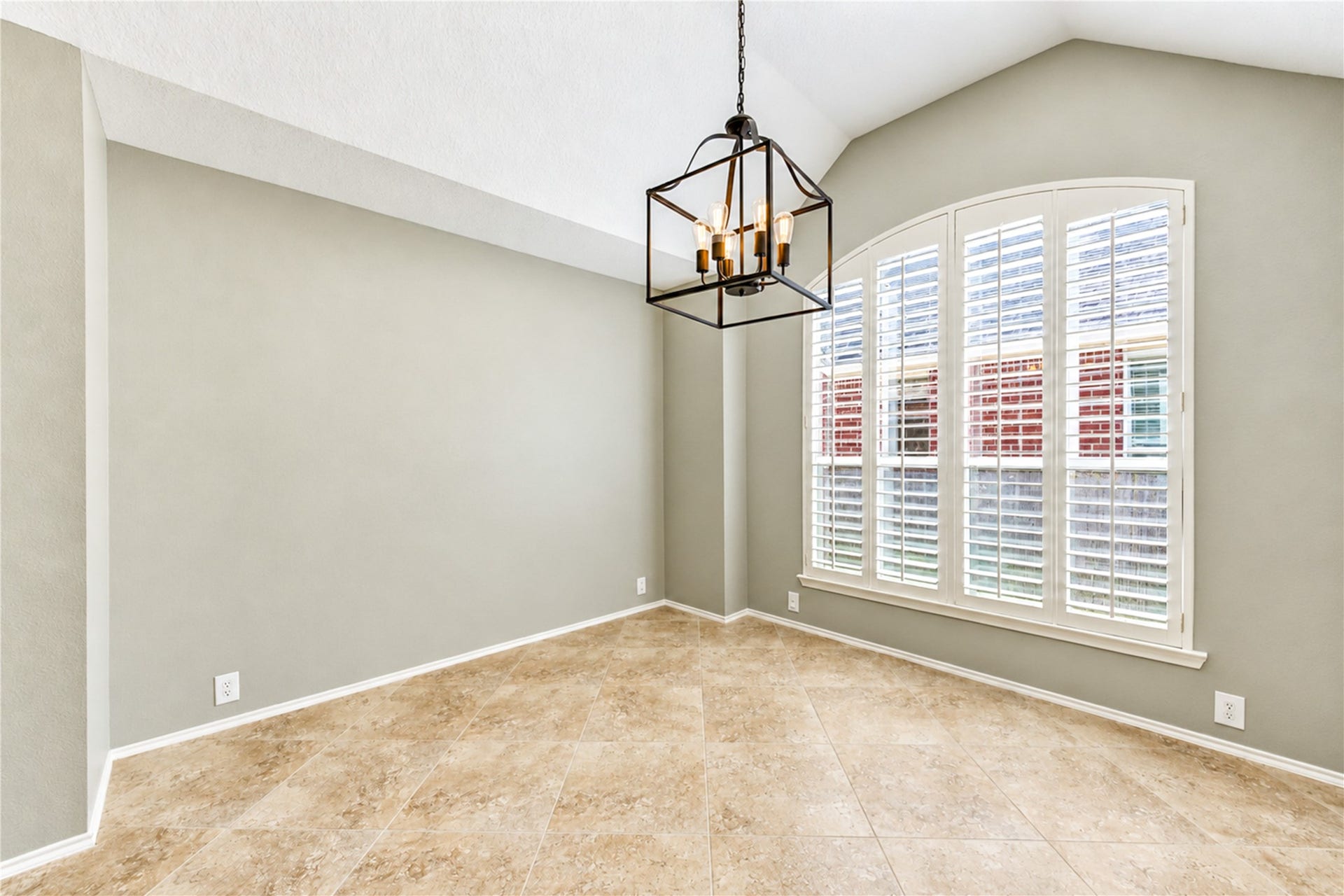 Imagine serving meals in this dining room with an elegant vaulted ceiling and large window.