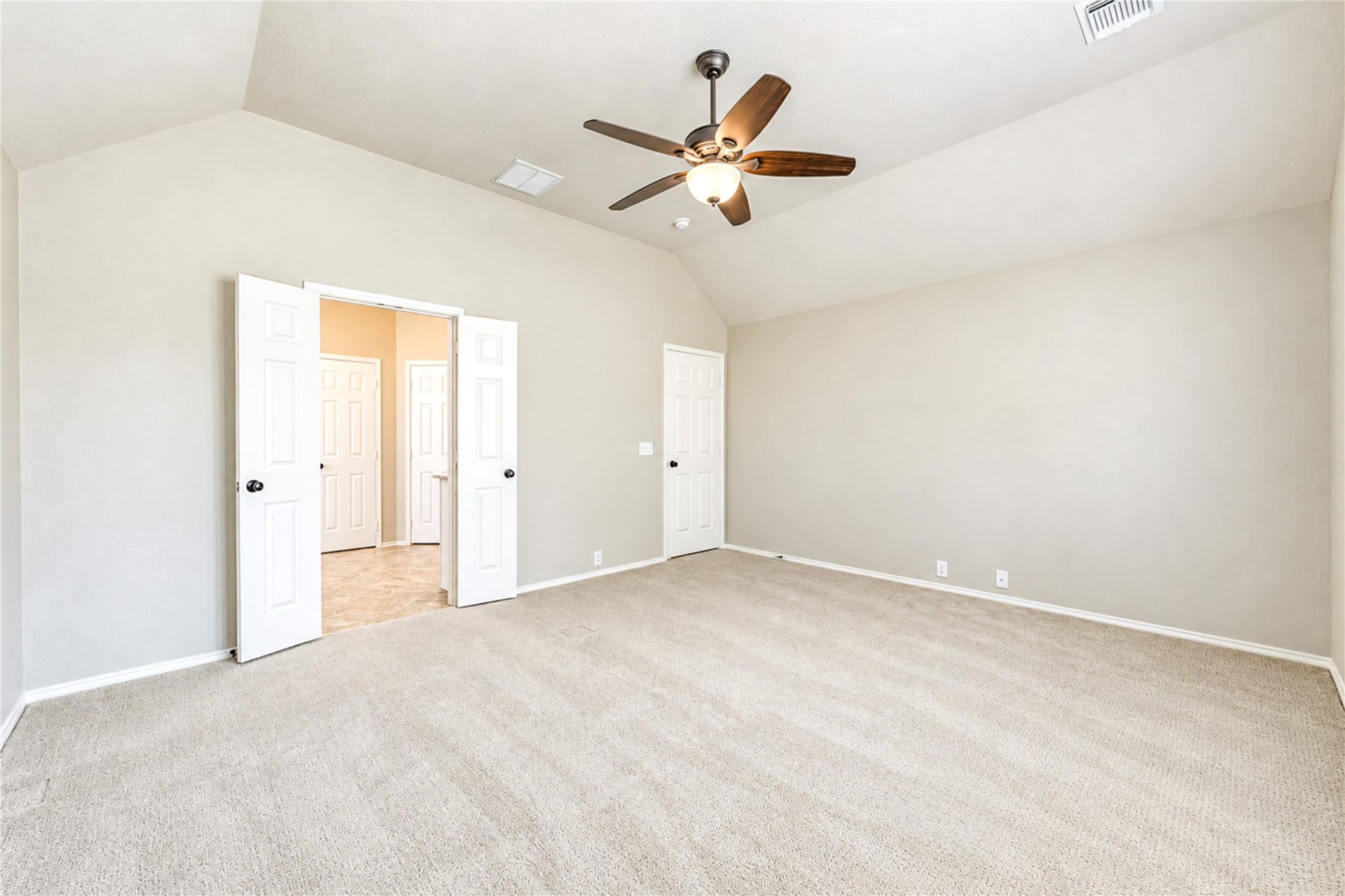 Primary bedroom with beautiful vaulted ceiling and well maintained carpet.