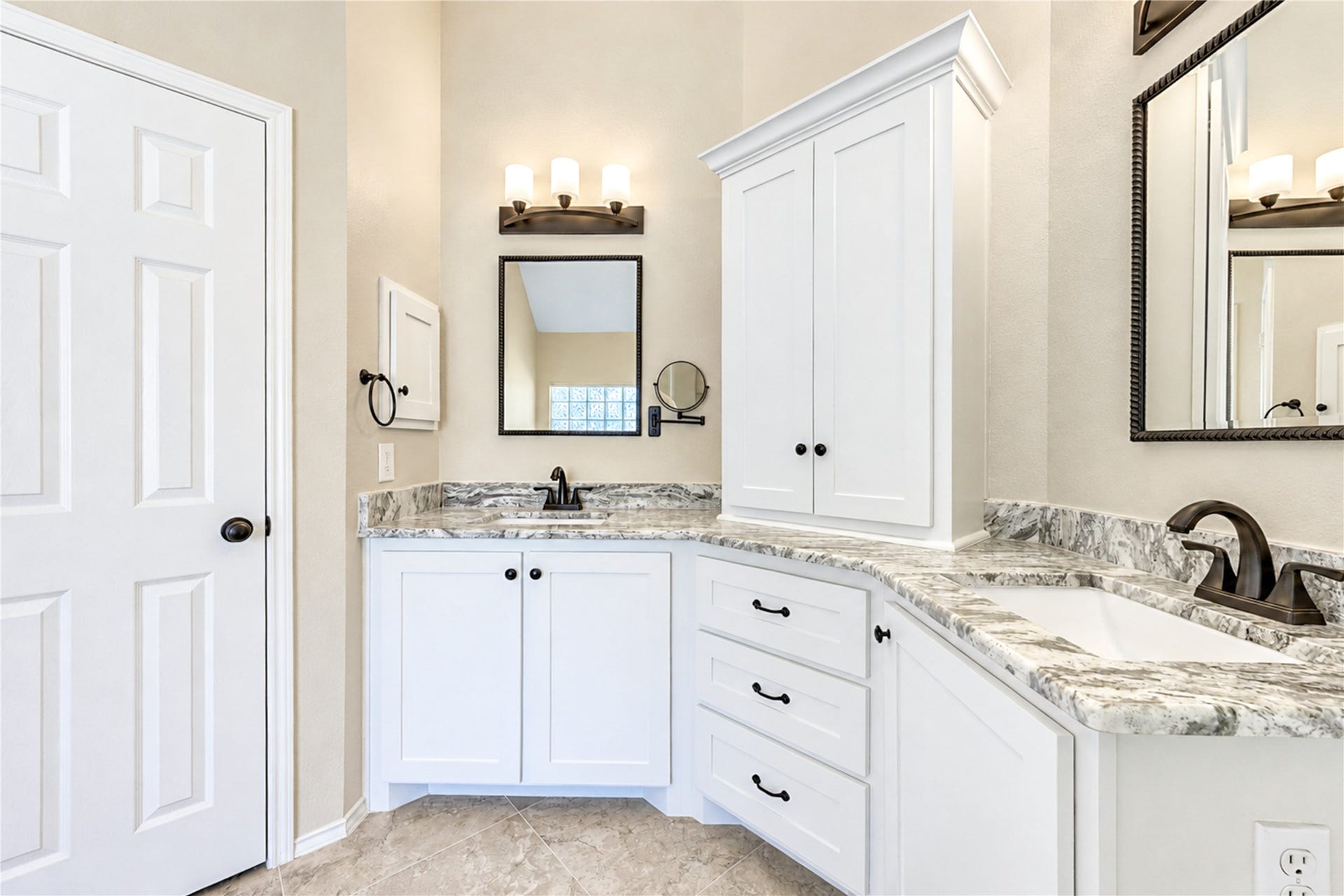 The primary bathroom features dual sinks, an updated countertop, and ample storage for everyday essentials.