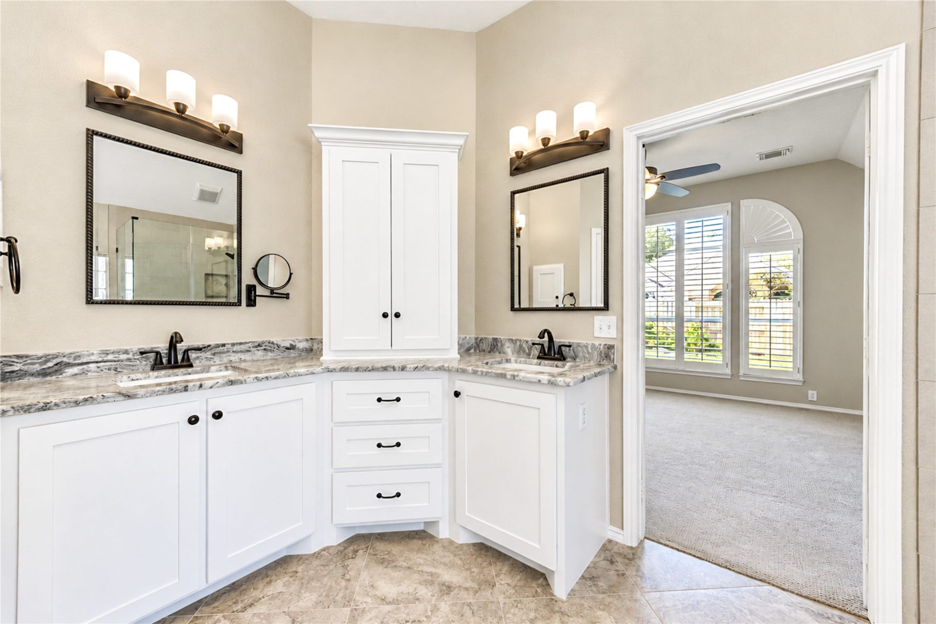 Primary bathroom ensuite with dual sinks and granite countertops.