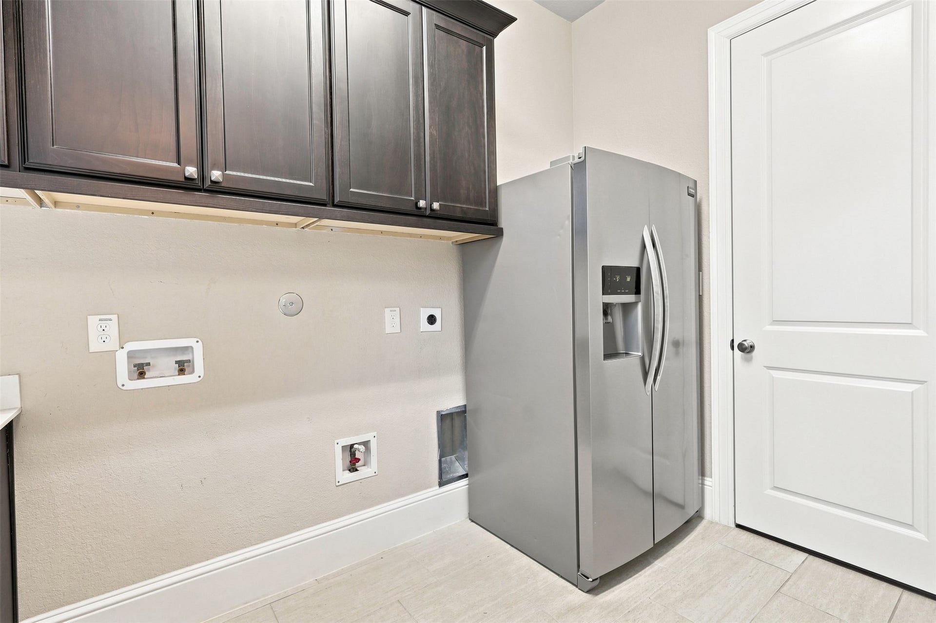 35 Gracenote Pl, The Woodlands, TX 77375 Spacious utility room with additional cabinetry and a full-size refrigerator.