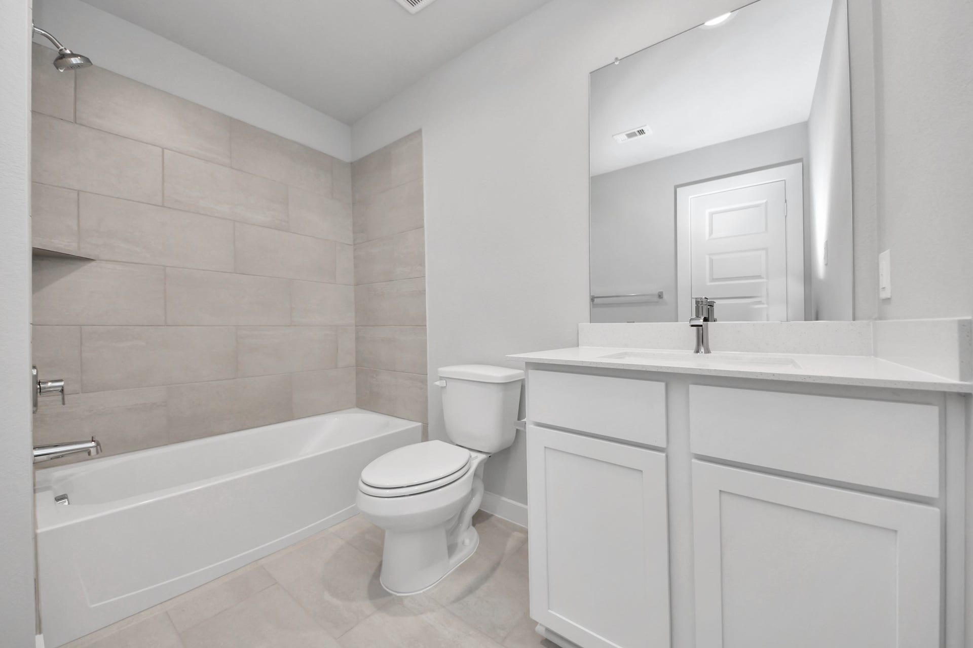 5826 Madison Trail Drive, Richmond, TX 77469 Secondary bath features tile flooring, bath/shower combo with tile surround, light stained wood cabinets, beautiful light countertop. Sample photo of completed home with similar floor plan. Actual colors and selections may vary.