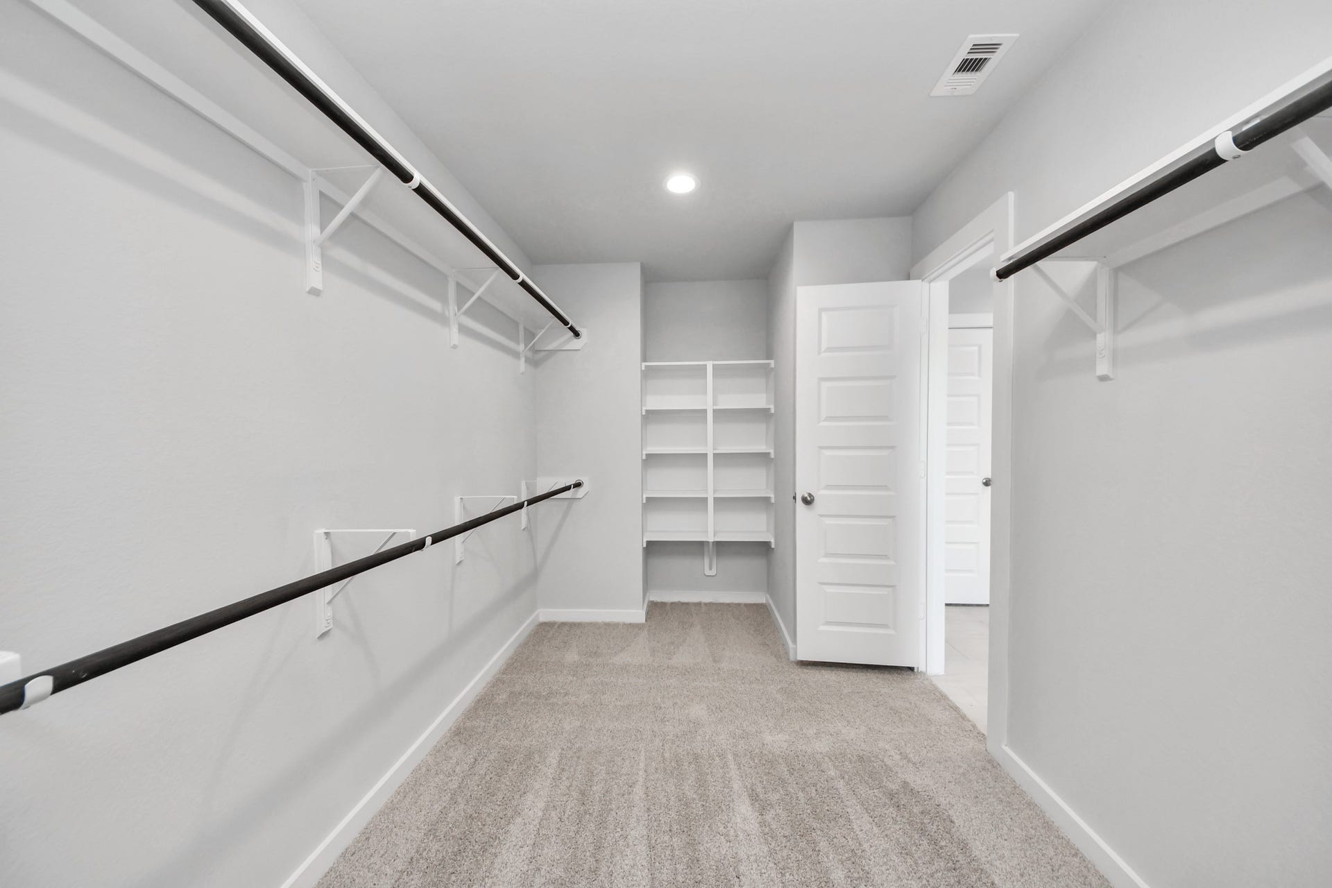 5826 Madison Trail Drive, Richmond, TX 77469 Walk-in closet that epitomizes luxury and practicality. This generously sized space features built-in shelving, offering abundant room for impeccable organization. High ceilings and recessed lighting create a bright and welcoming ambiance. Sample photo of completed home with similar floor plan. Actual colors and selections may vary.