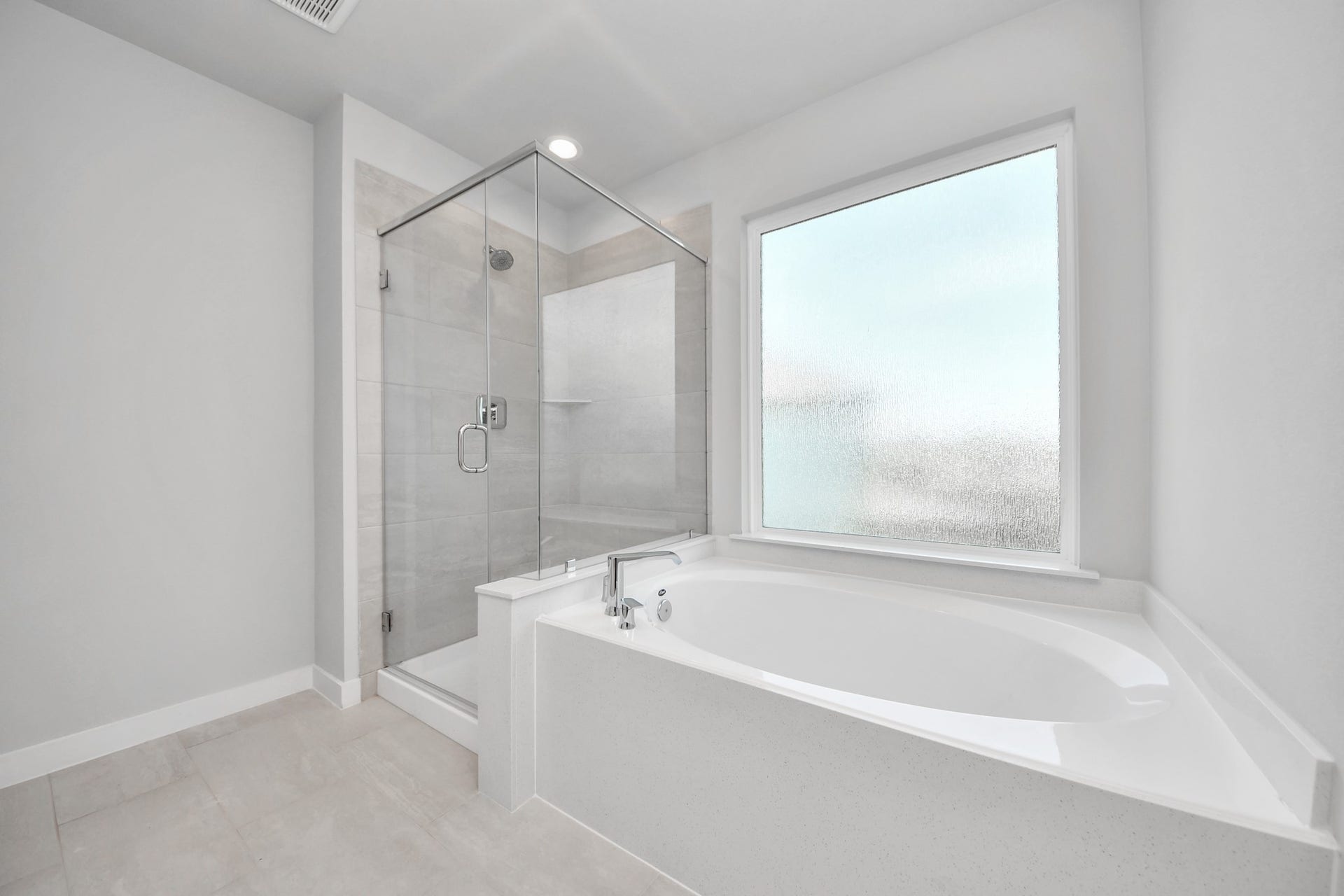 5826 Madison Trail Drive, Richmond, TX 77469 Escape to a spa-like oasis in this primary bathroom. Enjoy a walk-in shower with tile surround, a separate garden tub with custom detailing, and an elegant vanity featuring light countertops, modern hardware, and beautiful recessed lights. Experience luxury and relaxation in every detail. Sample photo of completed home with similar floor plan. Actual colors and selections may vary.