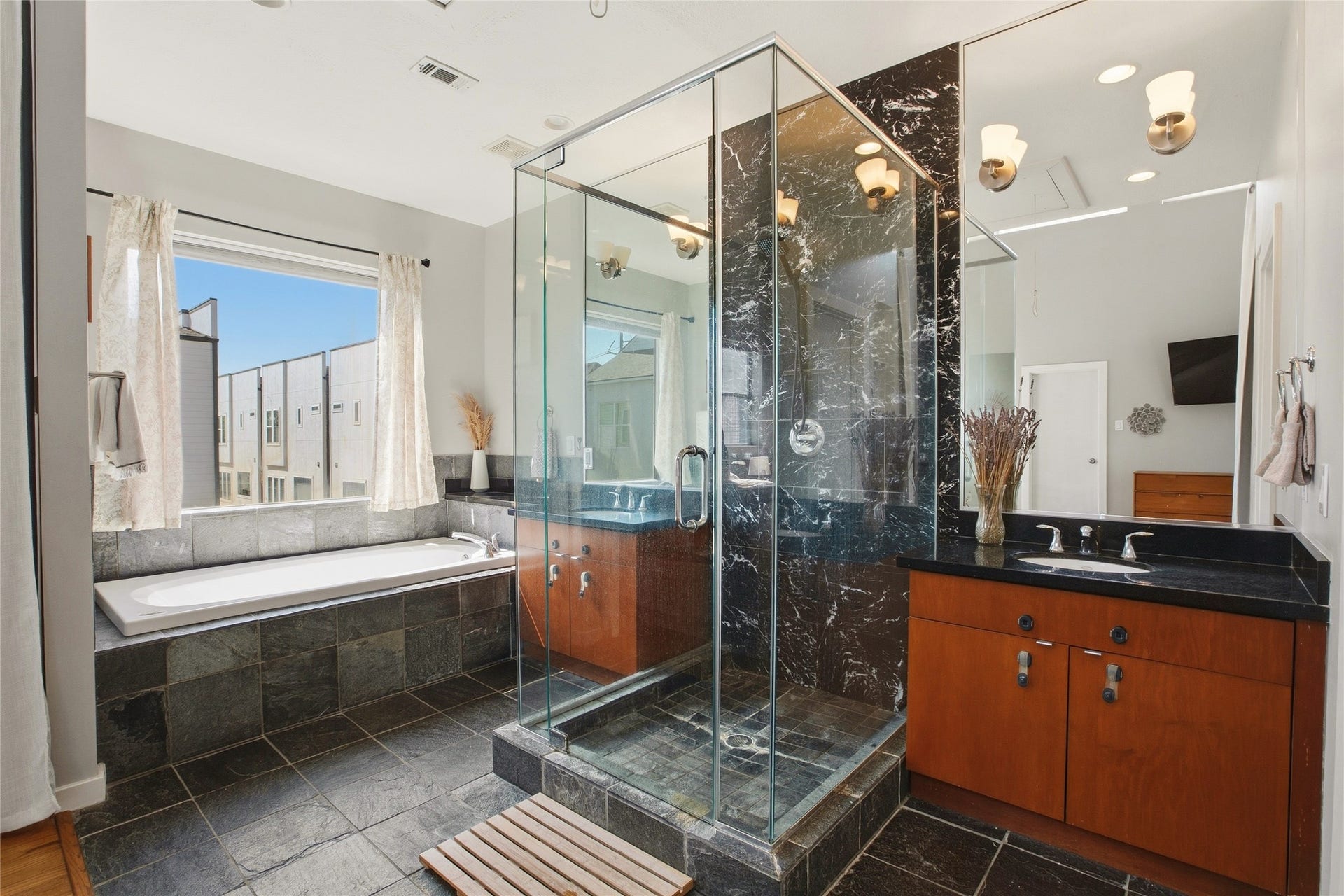 1803 Oneil Street, #C, Houston, TX 77019 Marble glass-enclosed shower and a garden tub with city rooftop views.