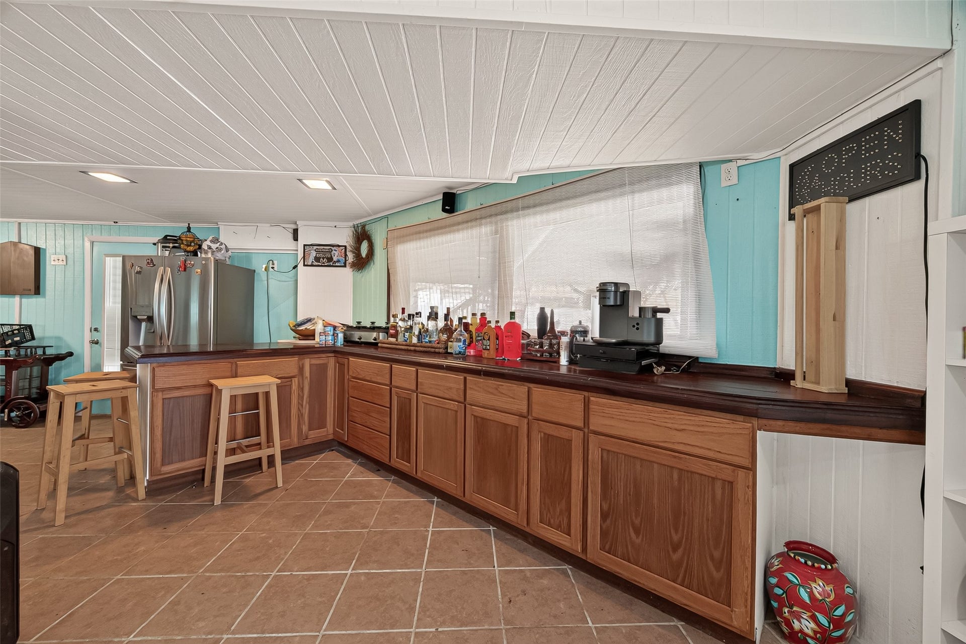 A fully equipped lower-level culinary bar featuring massive counter prep space, ideal for catering large poolside gatherings and waterside events.