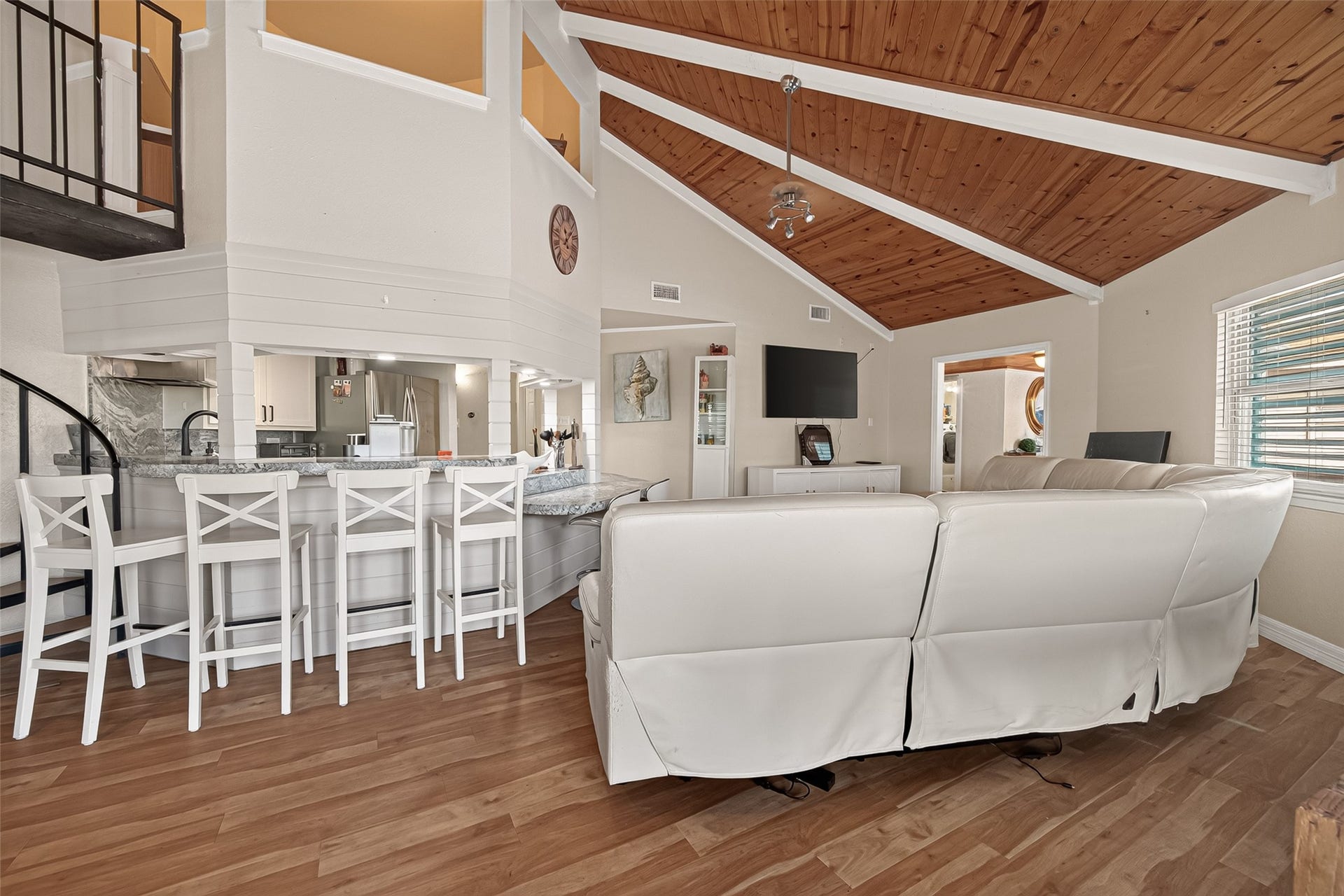 Sloping roof lines and angled ceiling planes lead the eye upward to the unique bird's-nest office hovering directly over the kitchen hub.