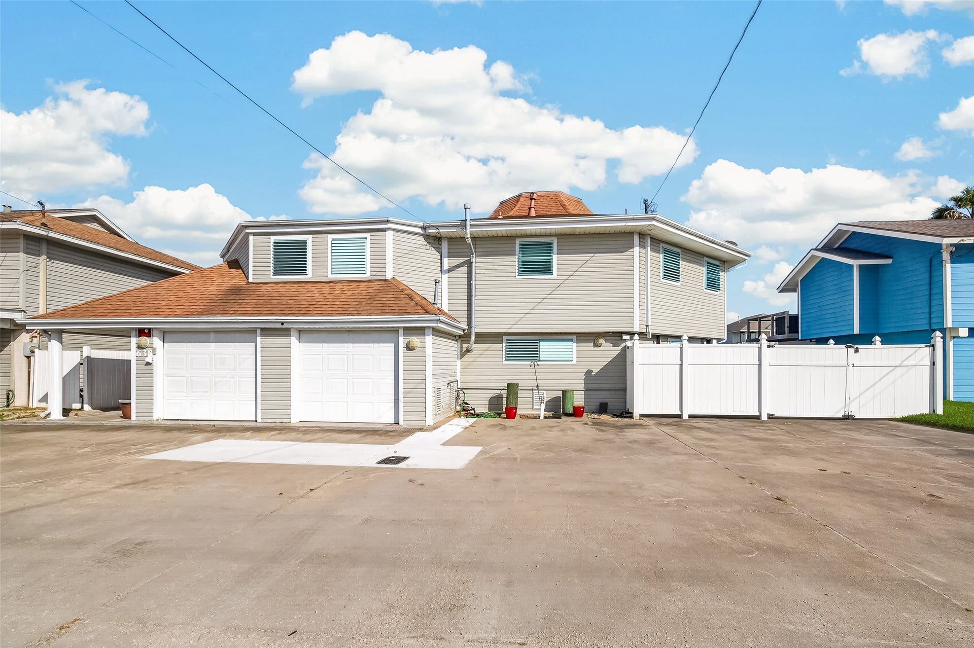 Architectural distinction meets coastal functionalitya unique facade, an expansive drive, and a covered patio space beside the garage deliver curb appeal and generous parking.