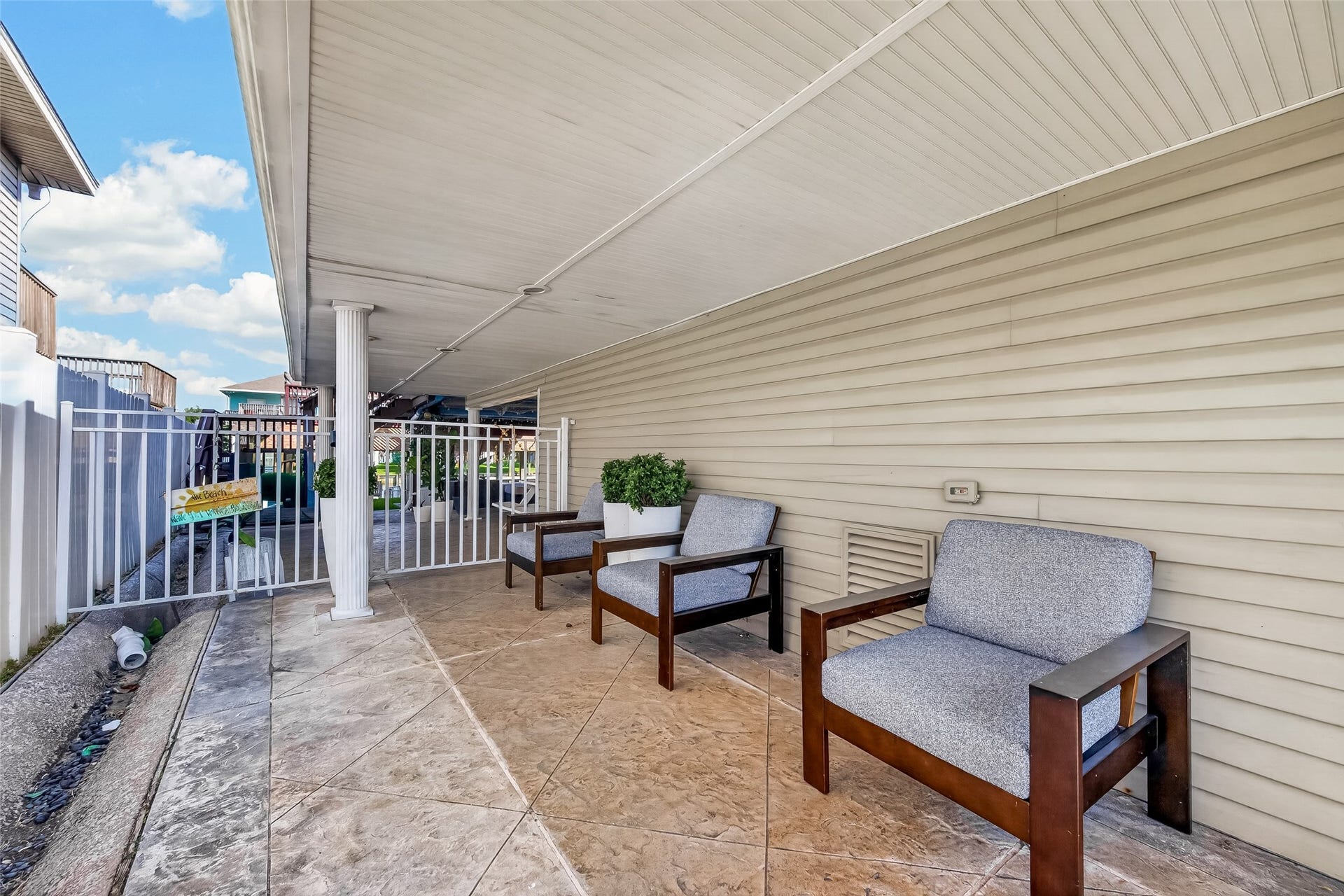 A shaded patio nestled beside the garageproviding a versatile, protected spot for casual outdoor gathering or extra covered staging space.