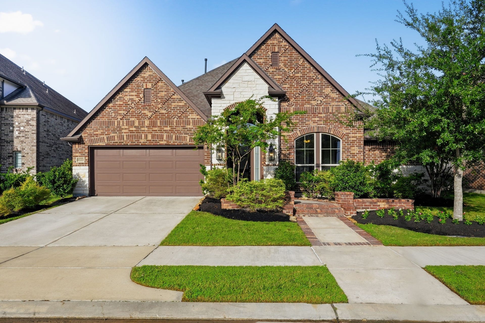 15223 Prairie Dog Town Lane, Cypress, TX 77433 Inviting front exterior showcasing the homes brick faade, landscaped entry, covered porch, and well-manicured lawn for a polished first impression.