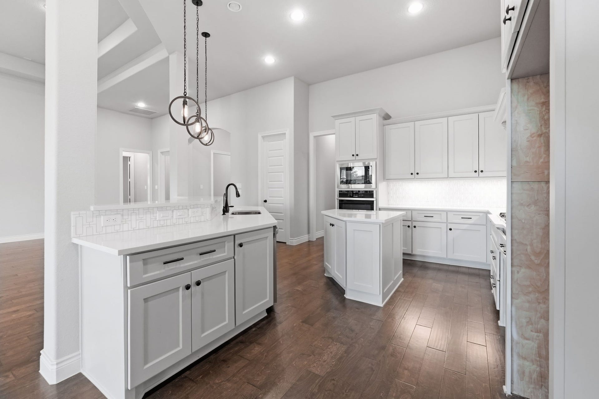15223 Prairie Dog Town Lane, Cypress, TX 77433 Another view of the kitchen highlighting the spacious island, sleek cabinetry, pendant lighting, and bright, open layout.