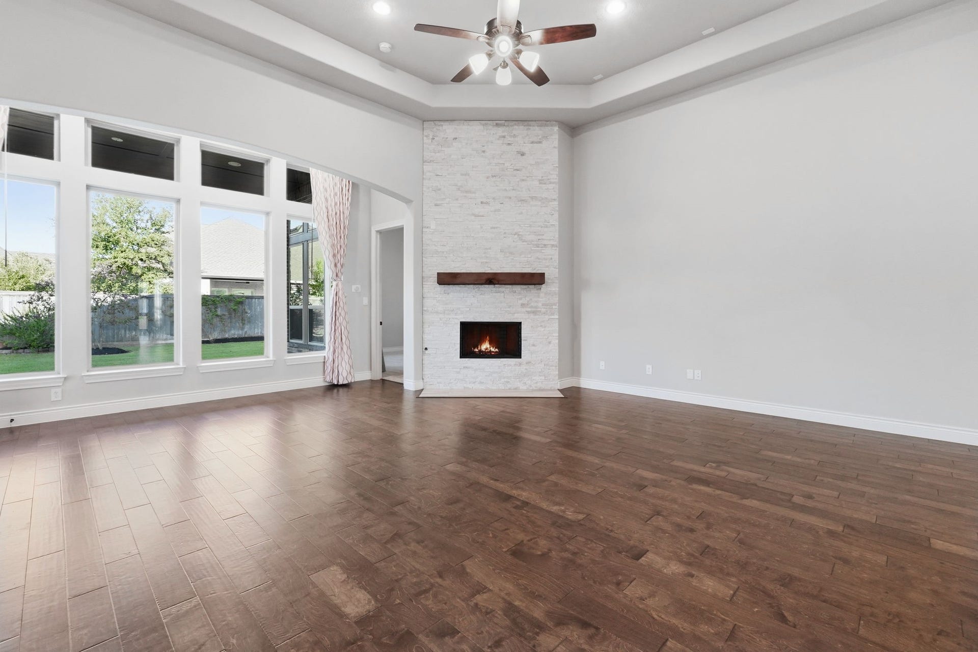 15223 Prairie Dog Town Lane, Cypress, TX 77433 Open living space highlighting the coffered ceiling, gas fireplace and expansive windows.