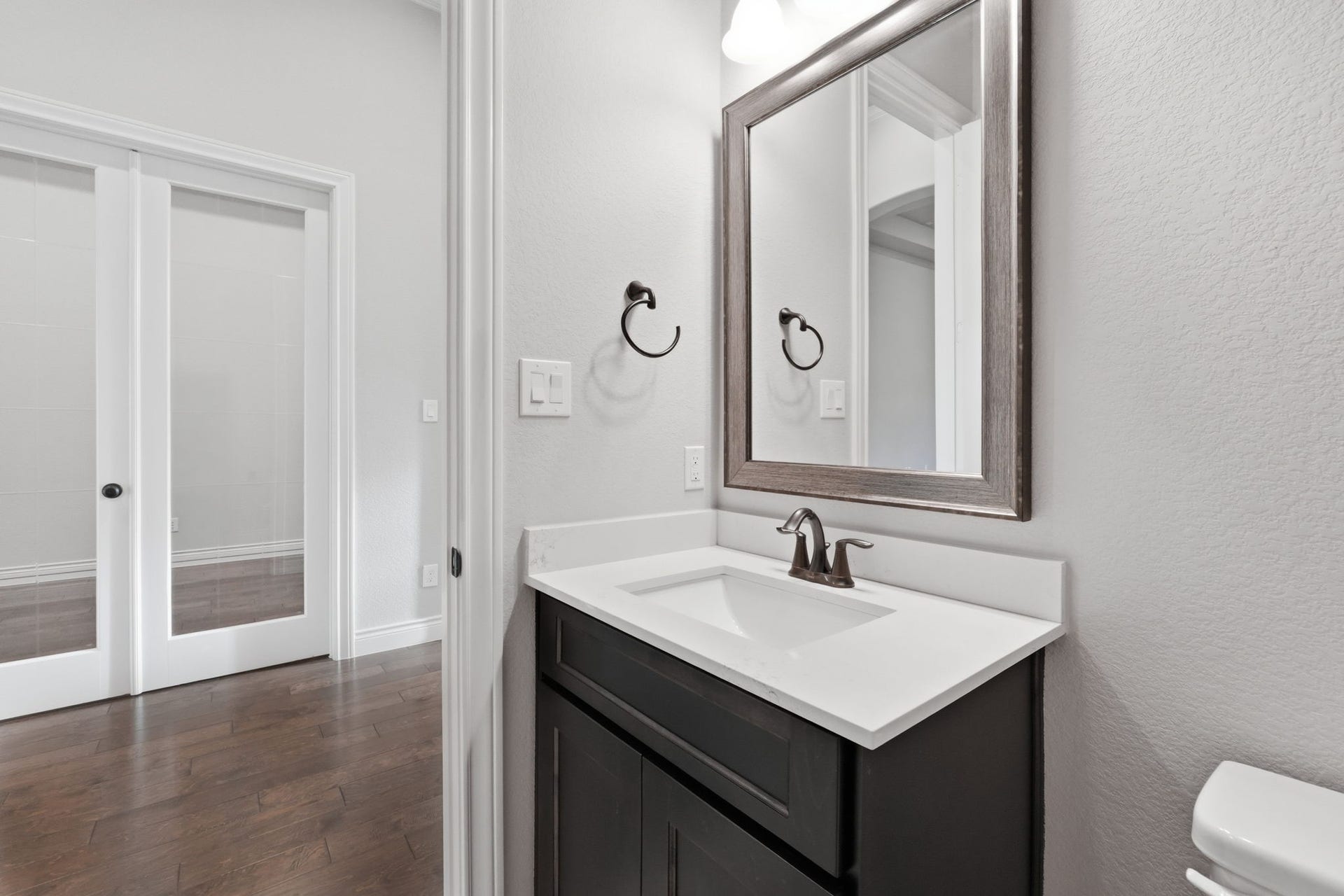 15223 Prairie Dog Town Lane, Cypress, TX 77433 Stylish powder room featuring a sleek vanity, framed mirror, and refined finishes that add a polished touch to the home.