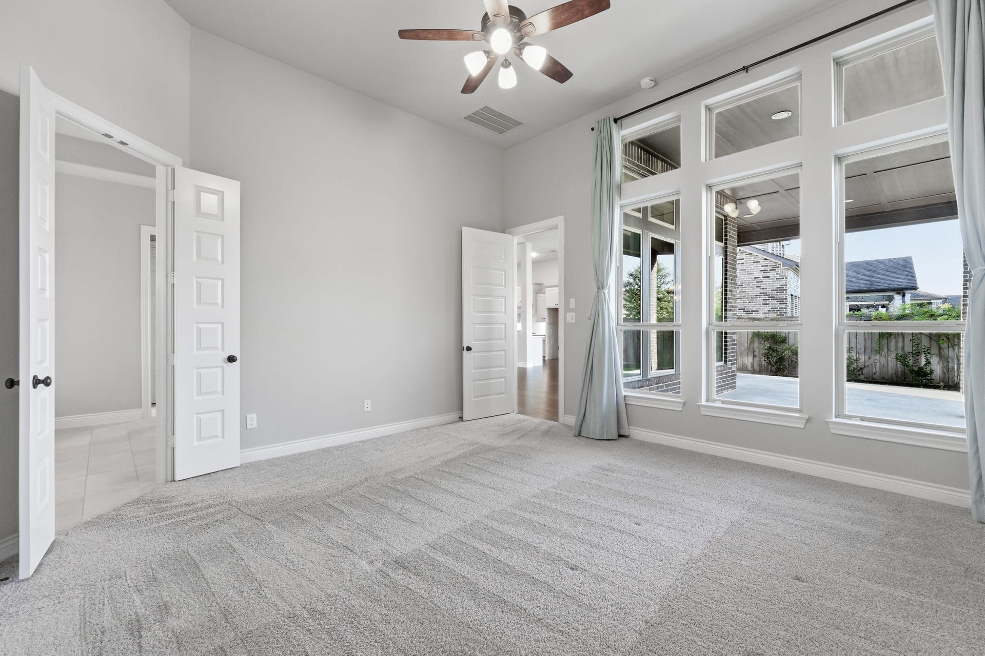 15223 Prairie Dog Town Lane, Cypress, TX 77433 Inviting primary retreat filled with natural light, generous windows, soaring ceilings, and serene views that create a bright and restful atmosphere.