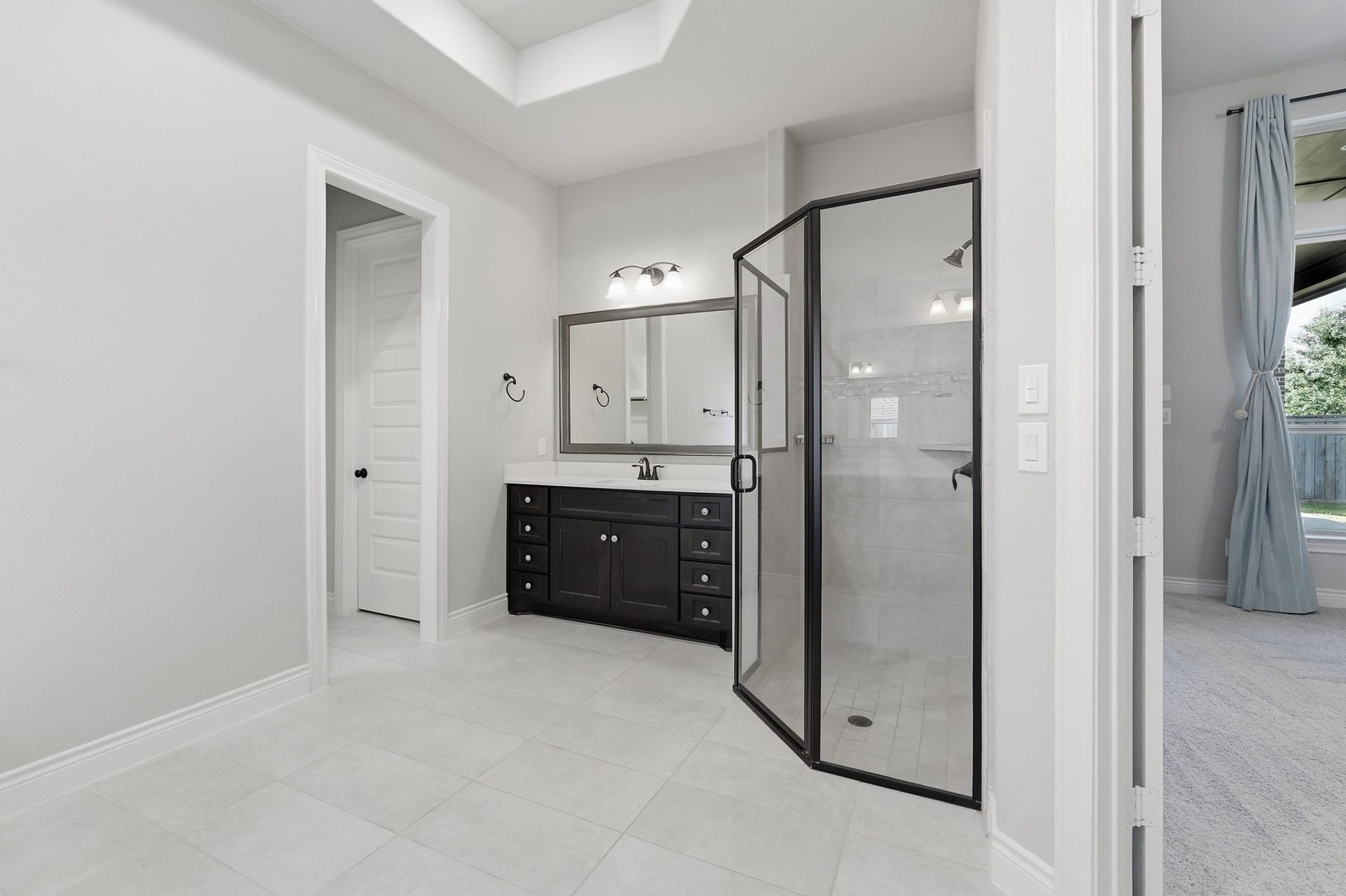 15223 Prairie Dog Town Lane, Cypress, TX 77433 Another view of the primary bath highlighting the spacious glass-enclosed shower and the separate vanity.