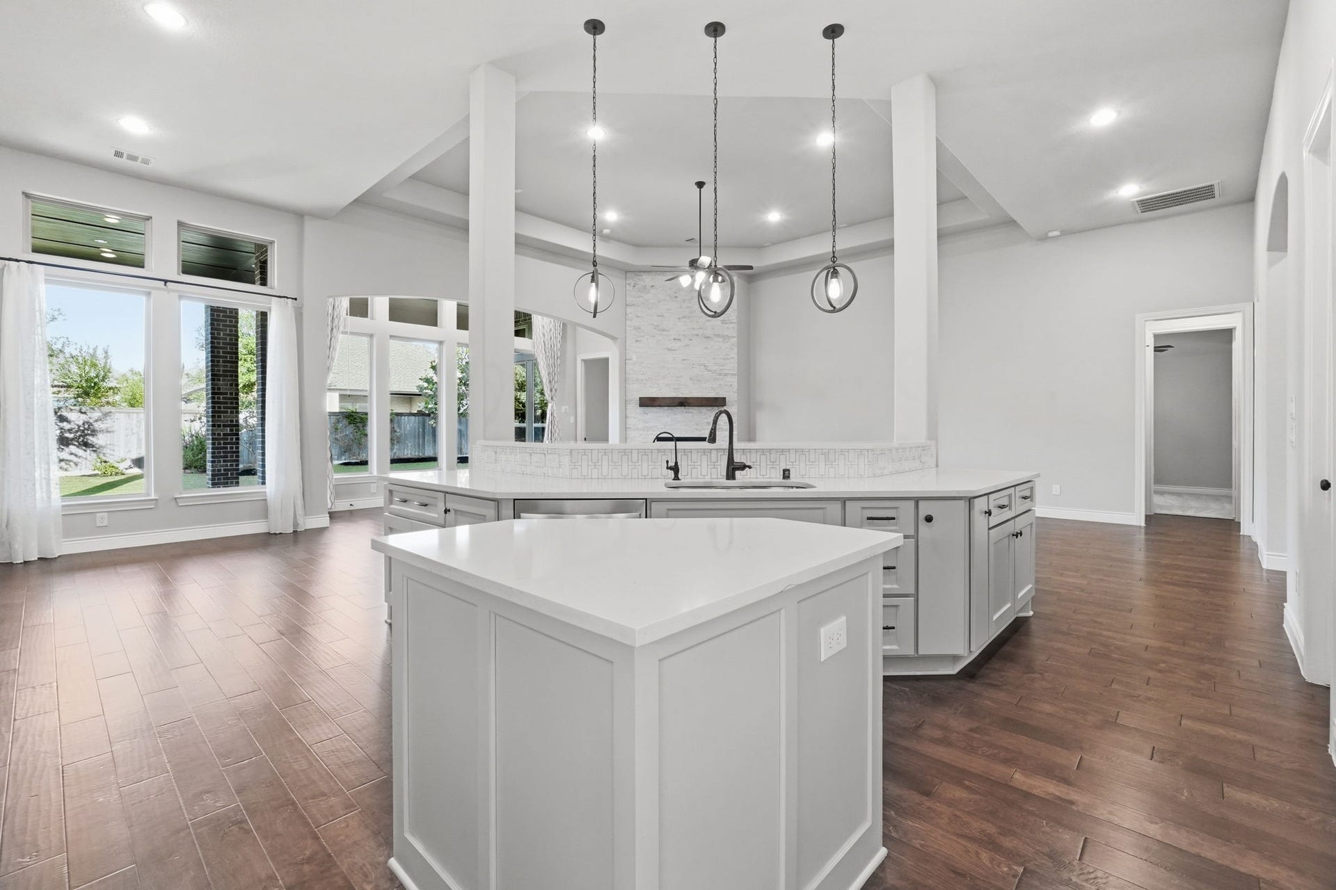 15223 Prairie Dog Town Lane, Cypress, TX 77433 Bright, open kitchen featuring a spacious island, crisp cabinetry, elegant pendant lighting, and a seamless connection to the surrounding living spaces.