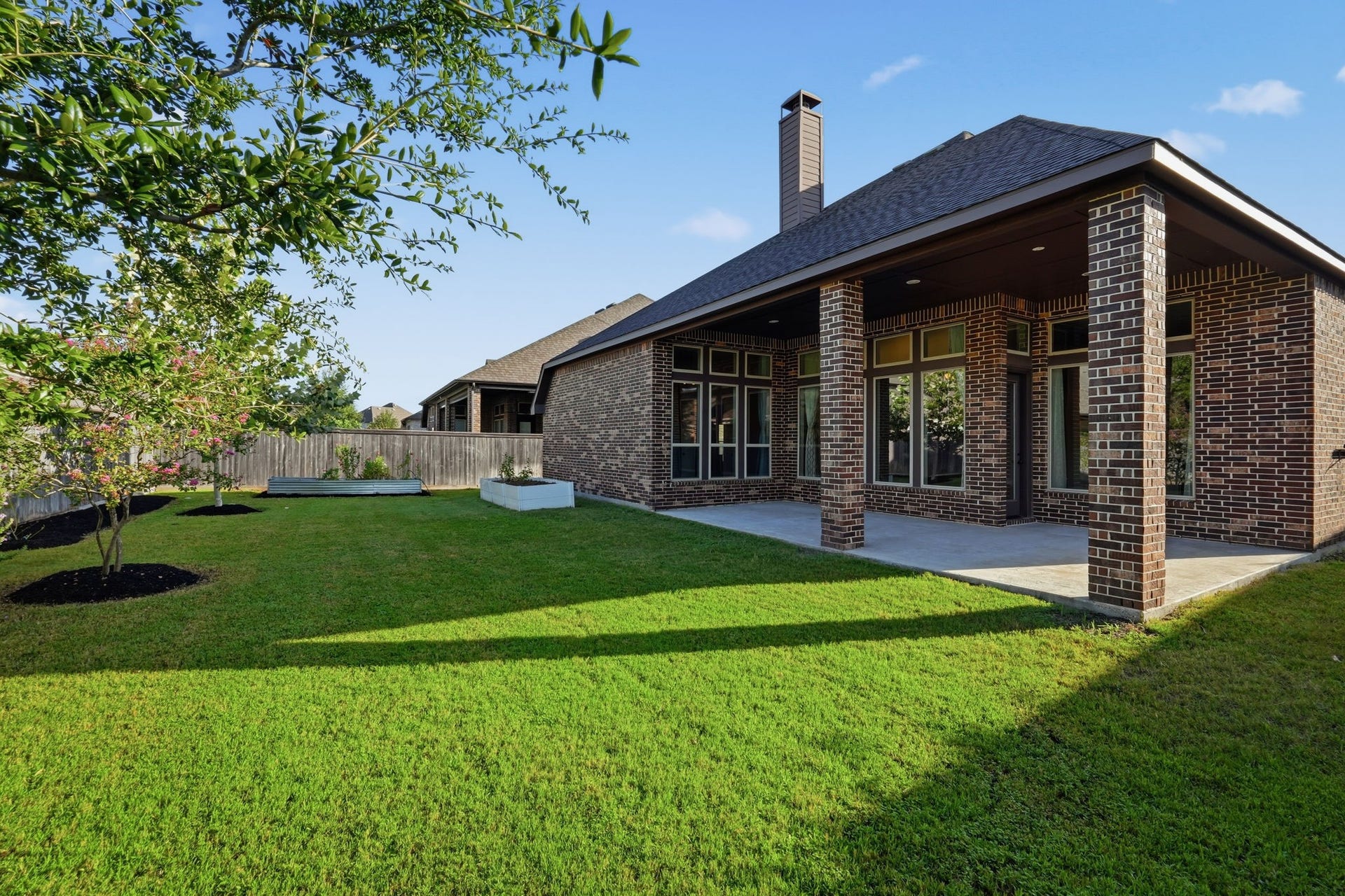 15223 Prairie Dog Town Lane, Cypress, TX 77433 Expansive backyard retreat featuring a covered patio, lush lawn, mature landscaping, and a spacious setting designed for outdoor entertaining and relaxation.