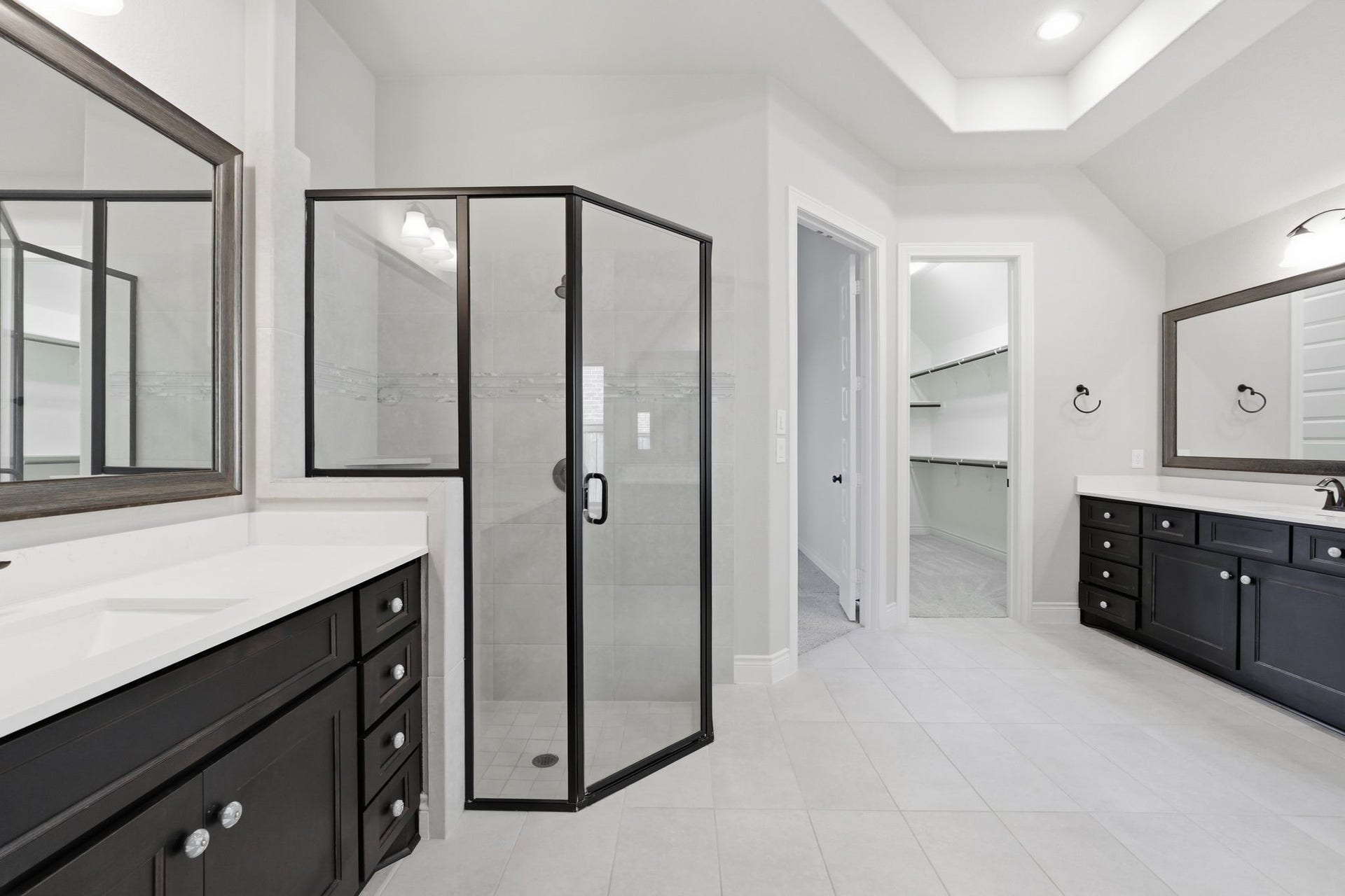15223 Prairie Dog Town Lane, Cypress, TX 77433 Spa-like primary bath featuring dual vanities, a dramatic freestanding tub, and a glass-enclosed shower, all accented by bright, refined finishes.