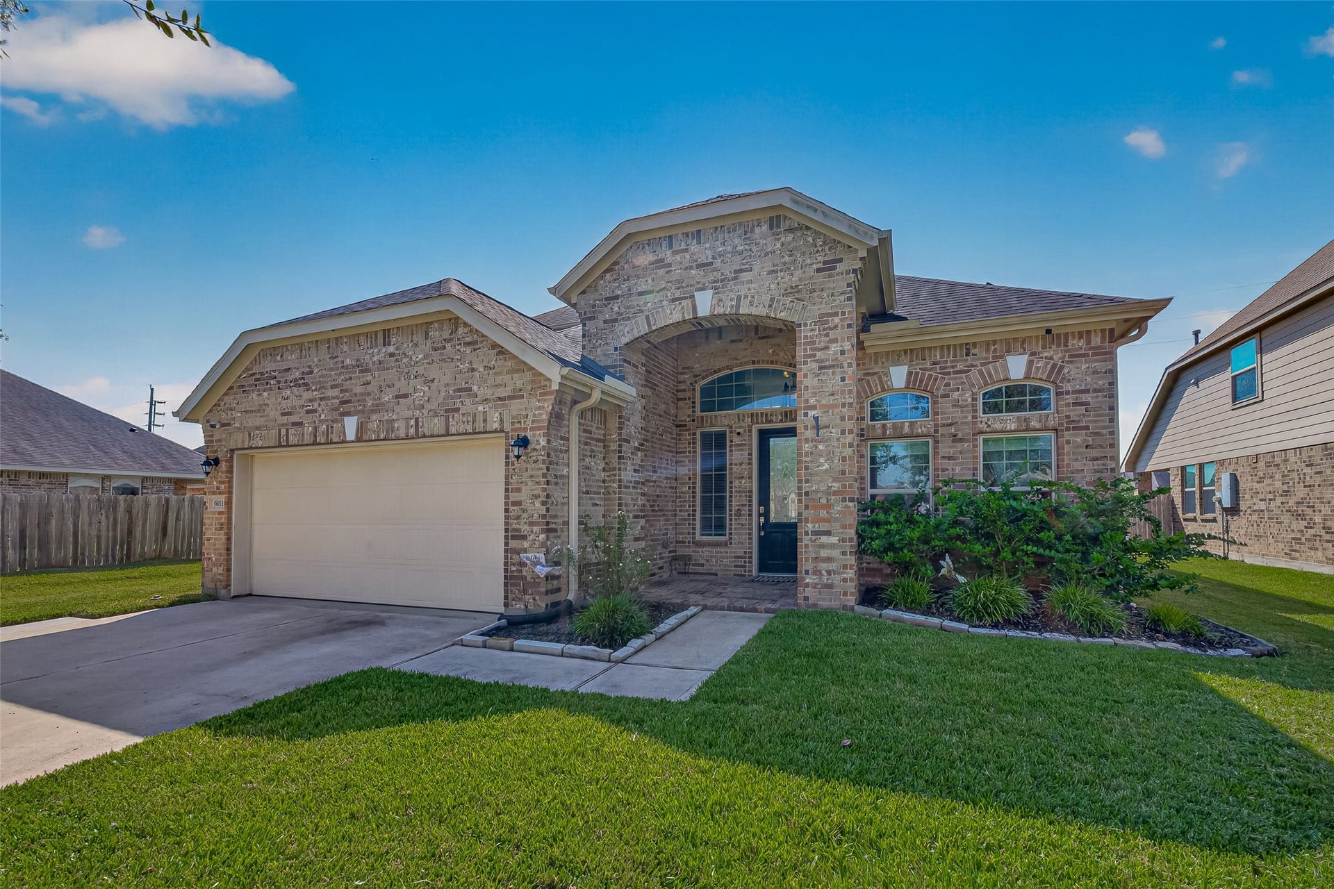 6111 Wayne Way, Rosenberg, TX 77471 Another look at the brick exterior, arched entrance, and front lawn at 6111 Wayne Way.