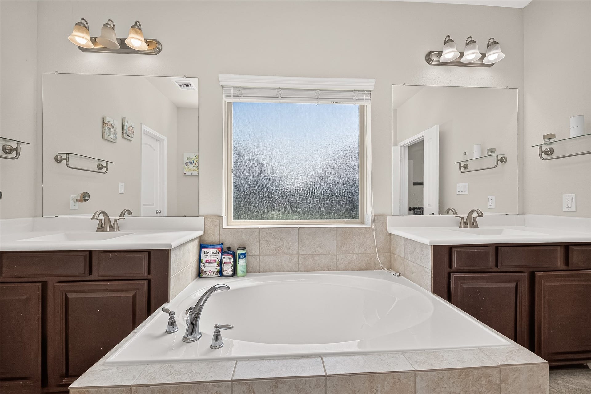 6111 Wayne Way, Rosenberg, TX 77471 Separate vanities frame the soaking tub, creating room for everyday routines.