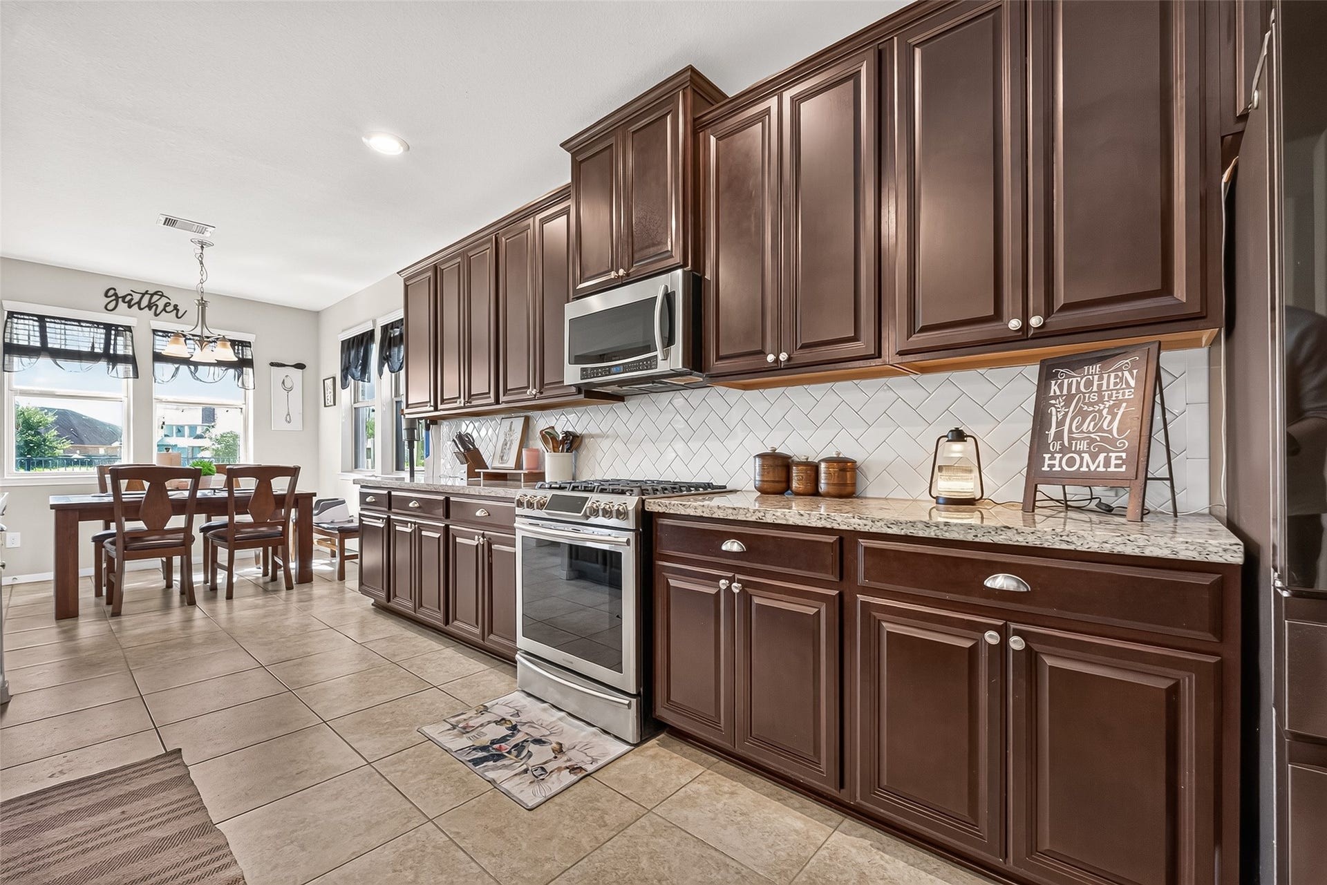 6111 Wayne Way, Rosenberg, TX 77471 Dark cabinetry, a gas range, and a patterned tile backsplash highlight the kitchen.