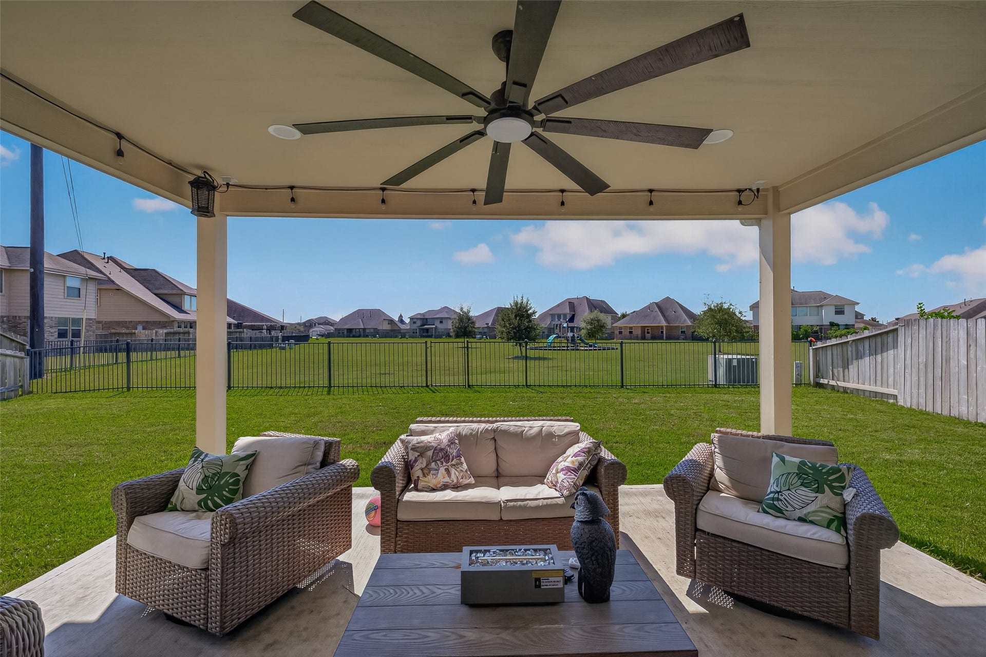6111 Wayne Way, Rosenberg, TX 77471 Relax beneath the covered patio with a ceiling fan and open views toward the park.