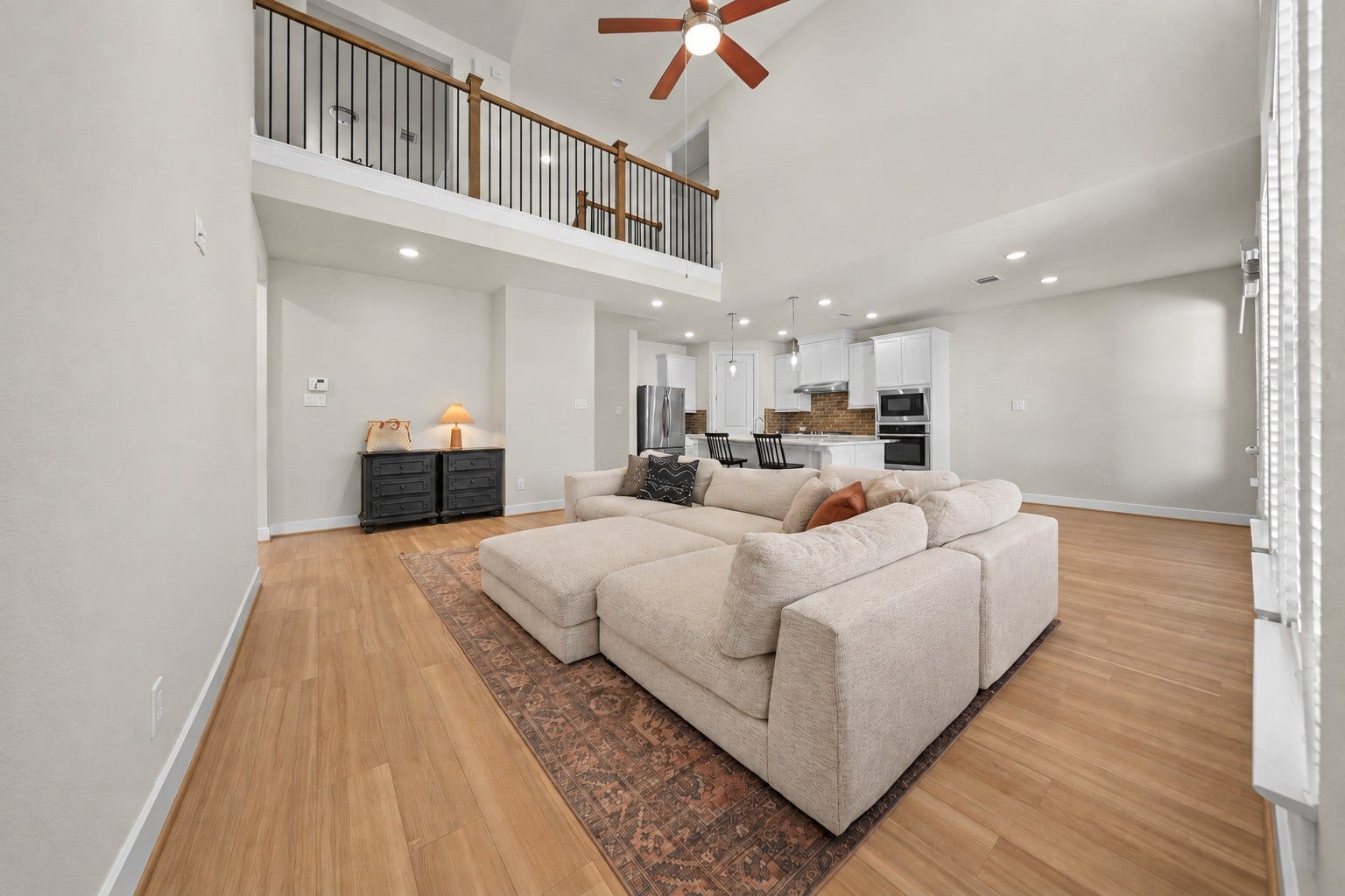 9231 Dearborn Knoll Drive, Cypress, TX 77433 Soaring ceilings and wood-look flooring give this living room an open, airy feel, with an easy view into the kitchen for everyday living and entertaining.