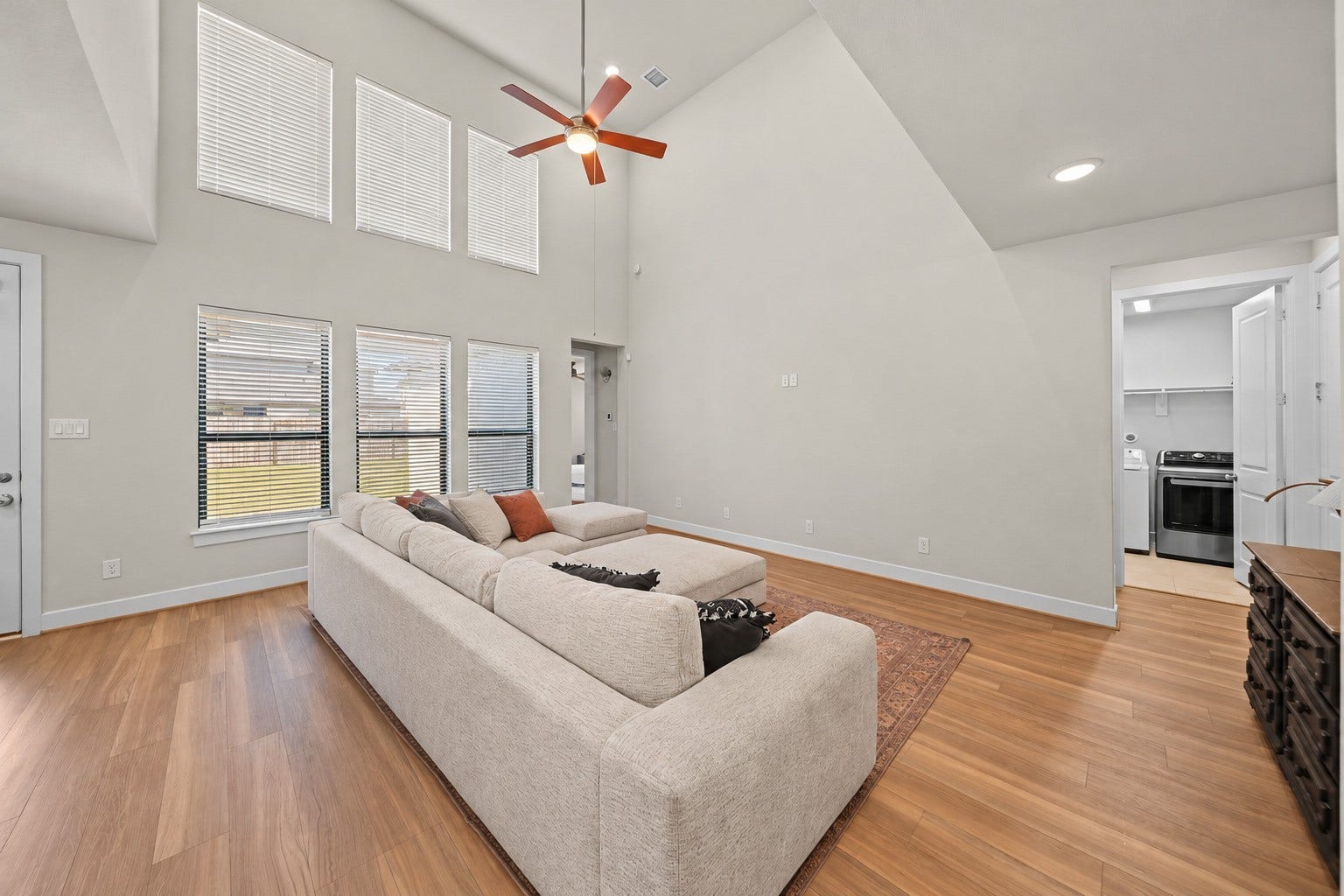 9231 Dearborn Knoll Drive, Cypress, TX 77433 Two-story windows with blinds bring in plenty of daylight and show off the height of this open family room.
