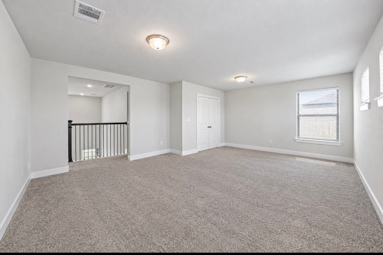 9231 Dearborn Knoll Drive, Cypress, TX 77433 Upstairs, a spacious game room offers flexible space for movie nights, playtime, or a hangout spot, with a window for natural light.