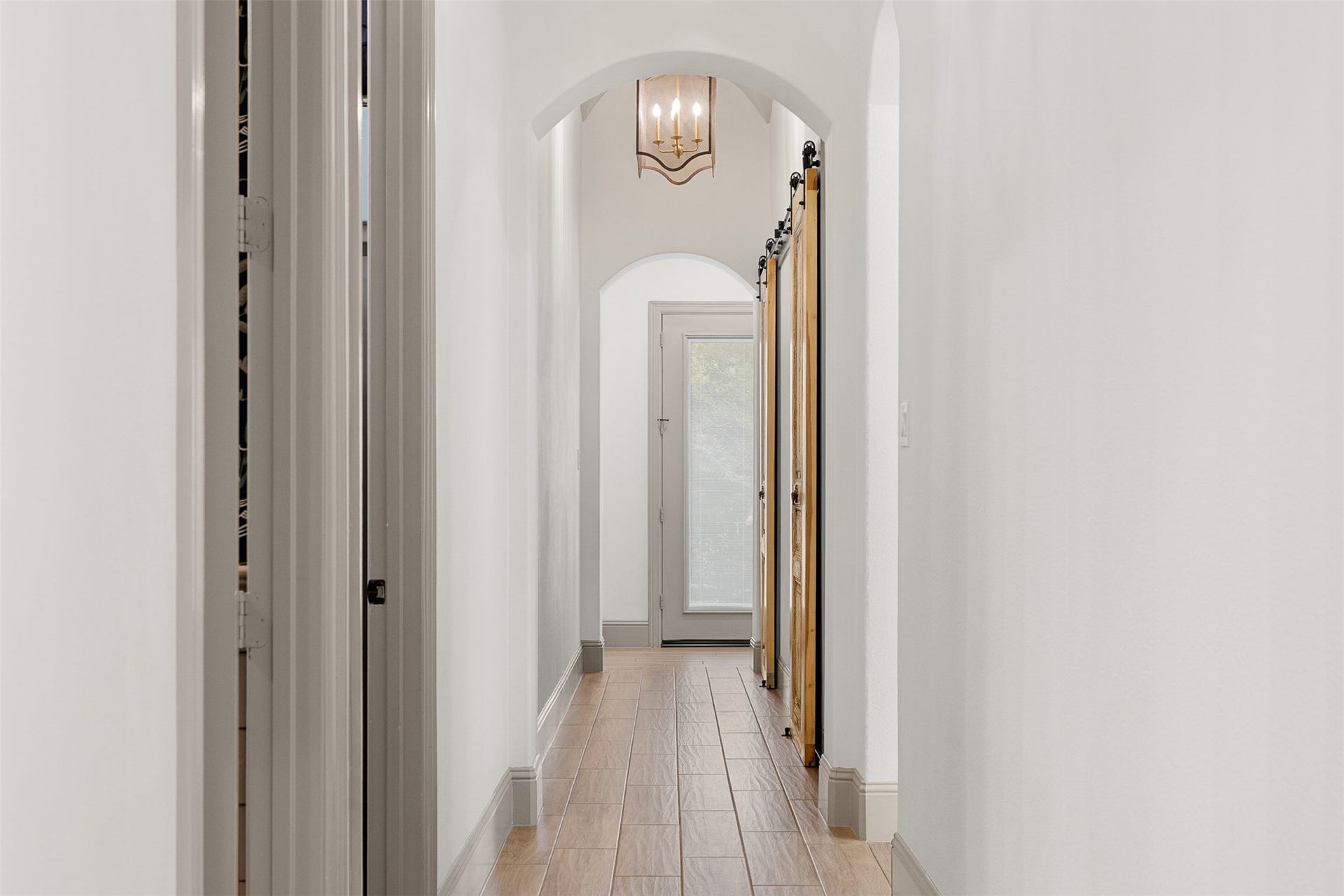 8603 Woods Hollow Trail, Fulshear, TX 77406 Downstairs, the hall has three barrel vaulted accent ceilings and chandeliers