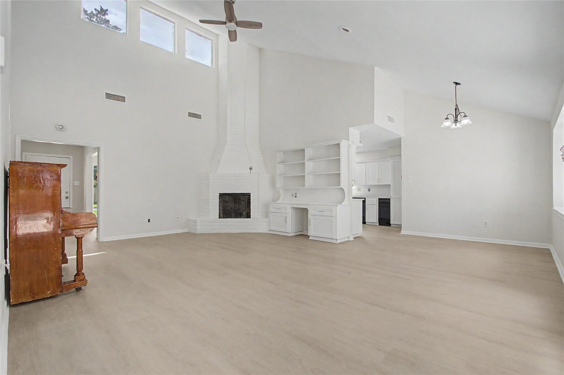 414 N Pecan Dr, Tomball, TX 77375 Formal living room featuring new luxury vinyl plank flooring, fresh paint, a gas fireplace, and built-in bookshelves