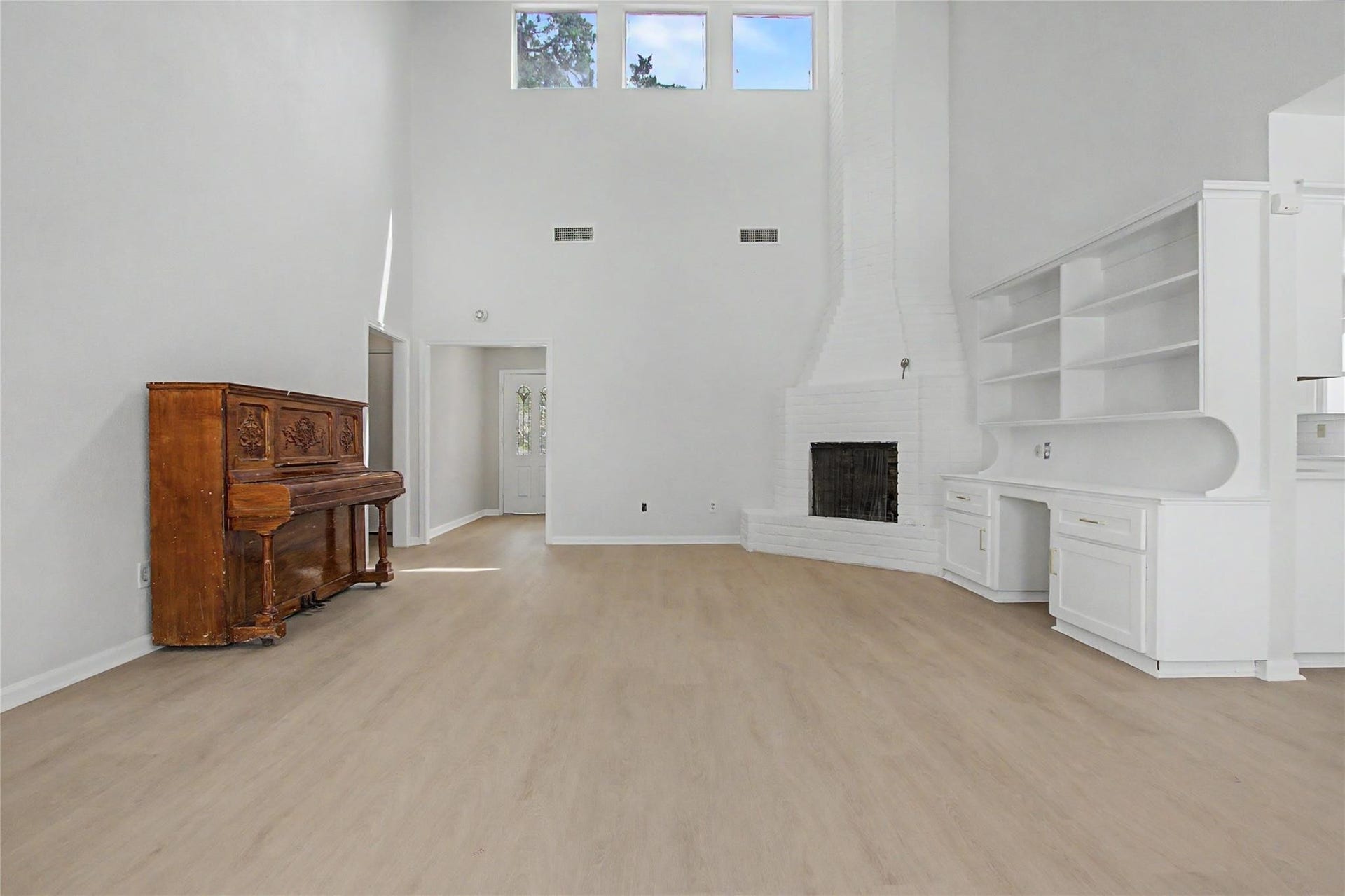 414 N Pecan Dr, Tomball, TX 77375 Formal living room featuring new luxury vinyl plank flooring, fresh paint, a gas fireplace, and built-in bookshelves