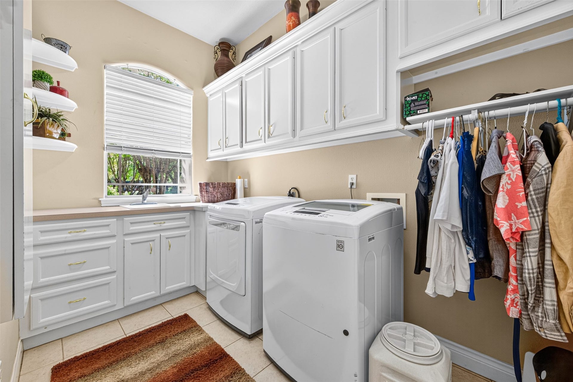Spacious laundry room  offers plenty of storage and a sink with a nice window for extra light.