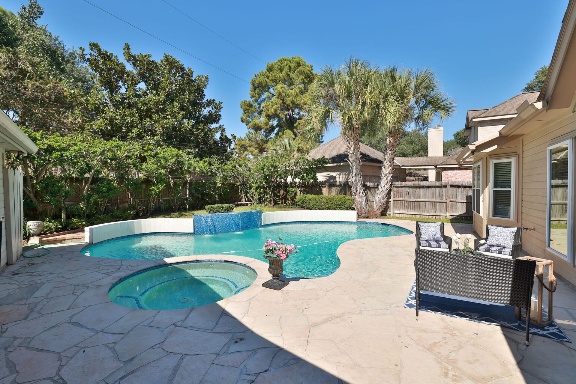 16107 Abberton Hill Drive, Spring, TX 77379 Private backyard oasis with sparkling pool, spa, and flagstone patio surrounded by lush landscaping.