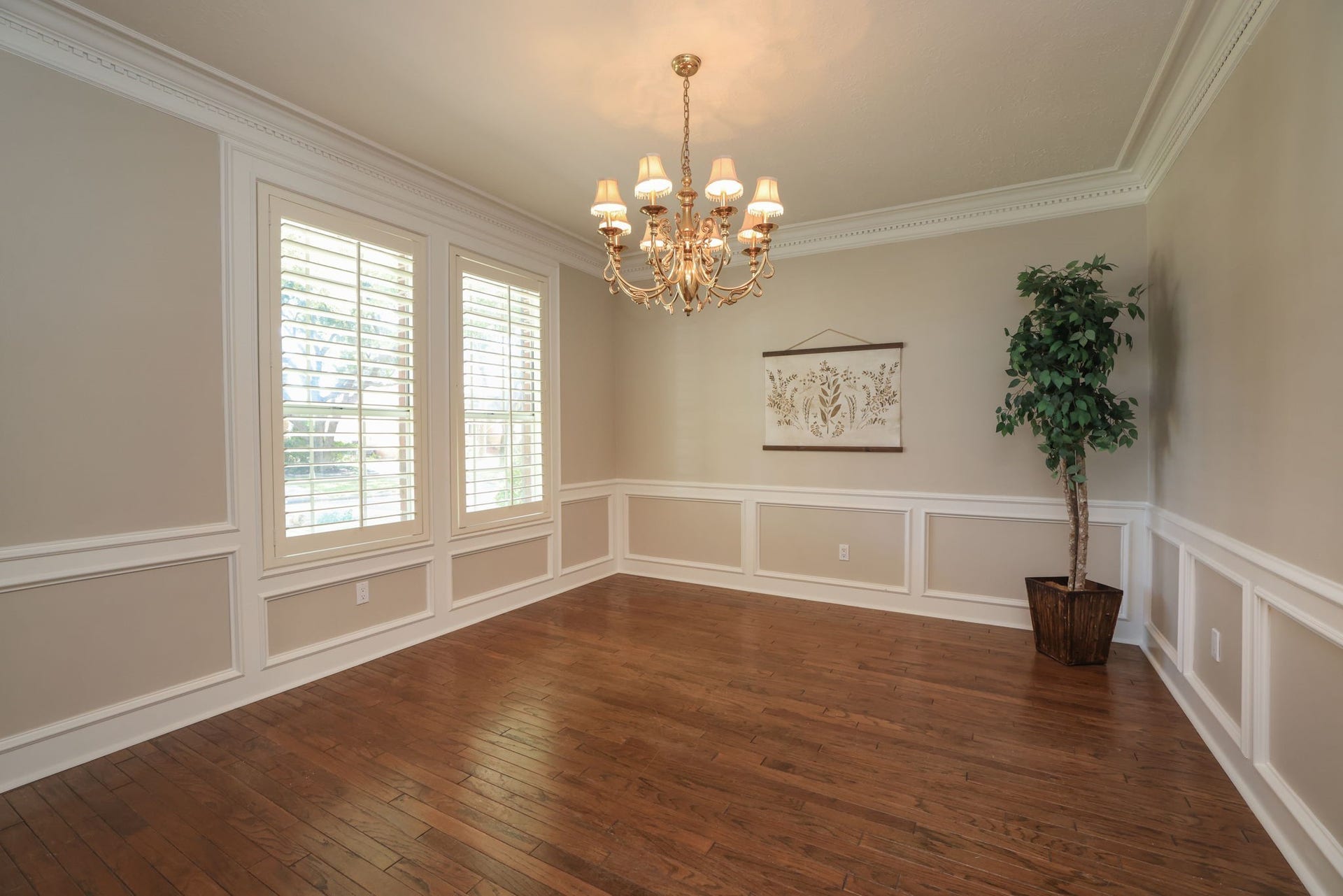16107 Abberton Hill Drive, Spring, TX 77379 Elegant formal dining room with wood floors, designer chandelier, plantation shutters, and detailed wainscoting.