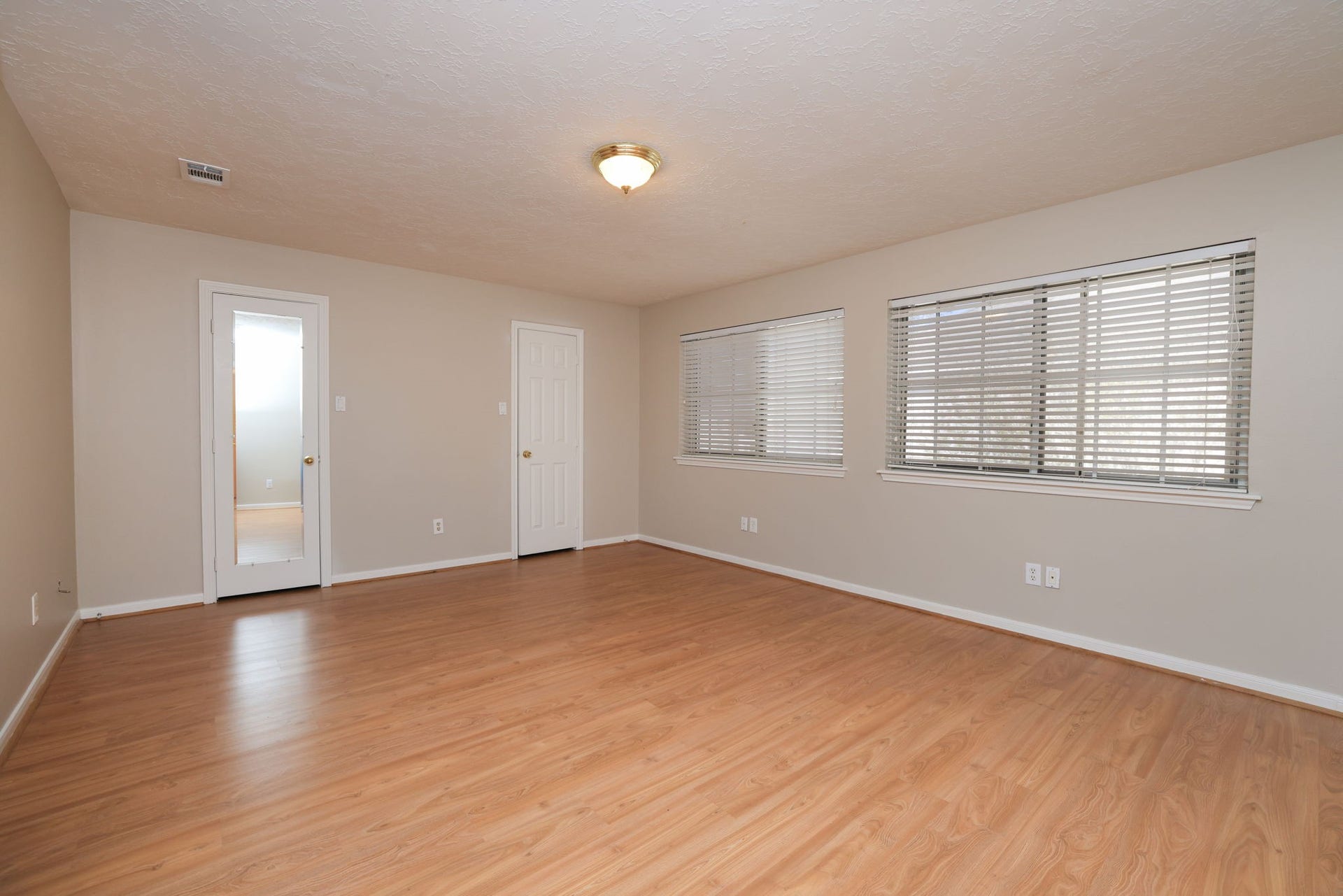 16107 Abberton Hill Drive, Spring, TX 77379 Large upstairs bedroom featuring wood-look flooring, double windows, and walk-in closet.
