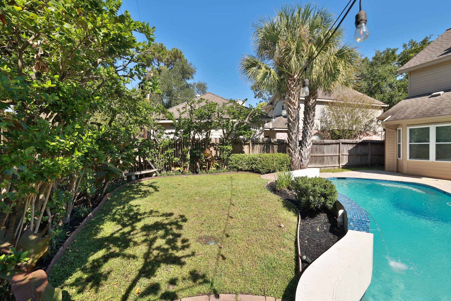 16107 Abberton Hill Drive, Spring, TX 77379 Manicured lawn and mature trees offer both sun and shade, creating a peaceful outdoor retreat.