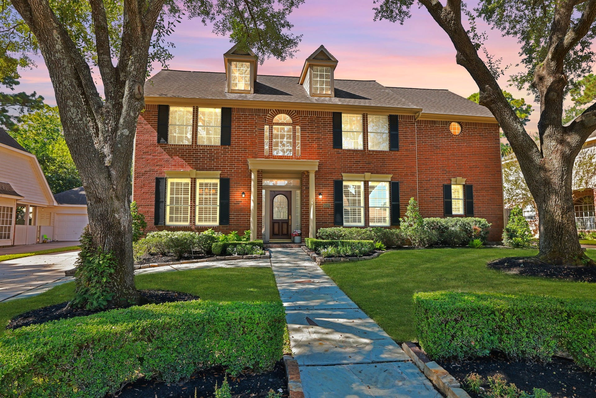 16107 Abberton Hill Drive, Spring, TX 77379 Classic Red Brick facade framed by mature trees and manicured landscaping offers timeless curb appeal.