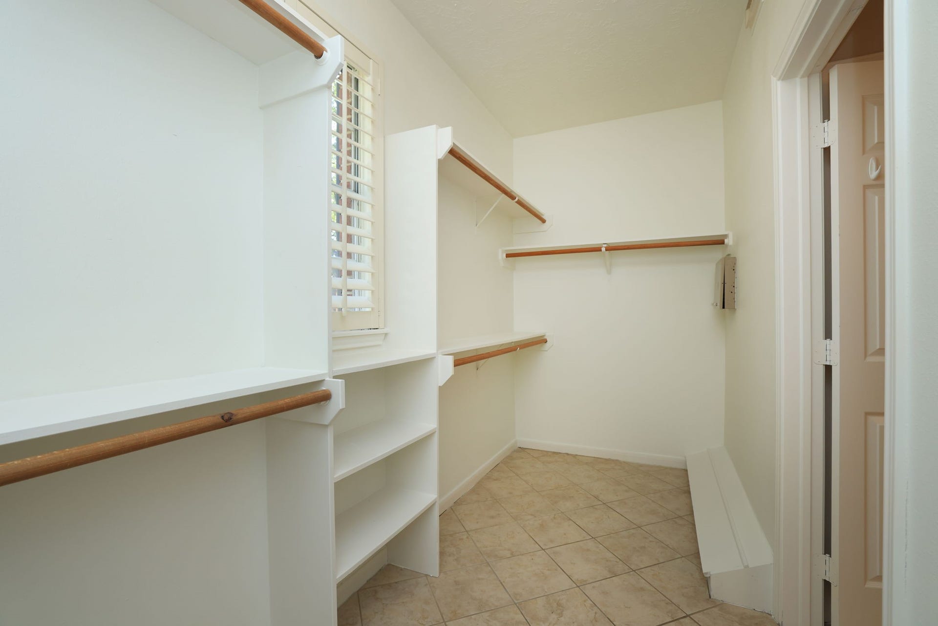 16107 Abberton Hill Drive, Spring, TX 77379 Spacious walk-in closet with custom built-ins, abundant hanging space, shelving, and a window for natural light.