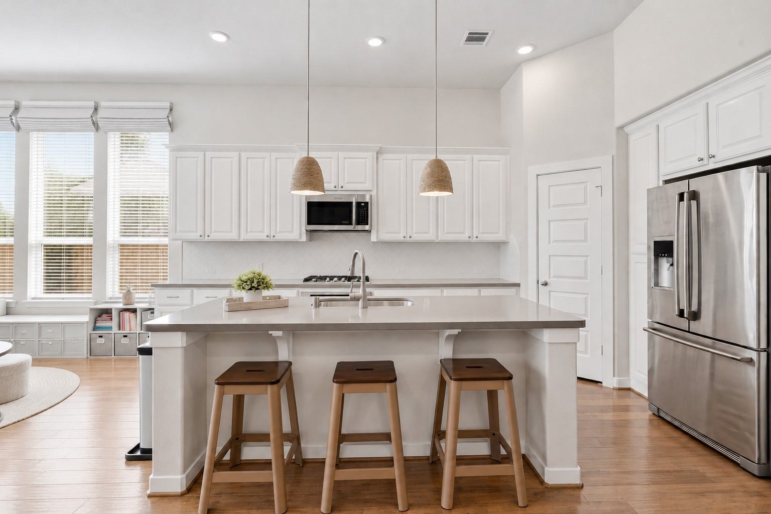 The heart of the home! This stunning chefs kitchen features elegant cabinetry, a spacious island with seating, sleek stainless steel appliances, and upgraded pendant lighting. Its perfect for gathering and entertaining.