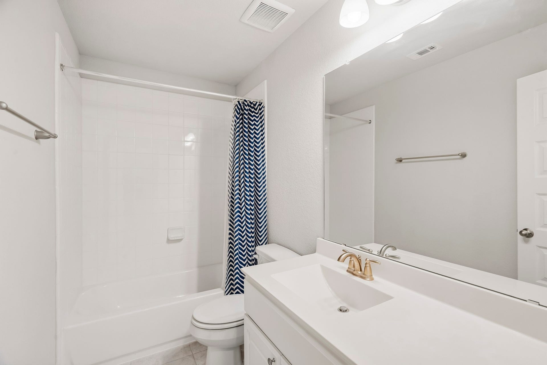 This upstairs bathroom is just off the game room and features quartz countertops, an oversized vanity, and spacious tub and shower.