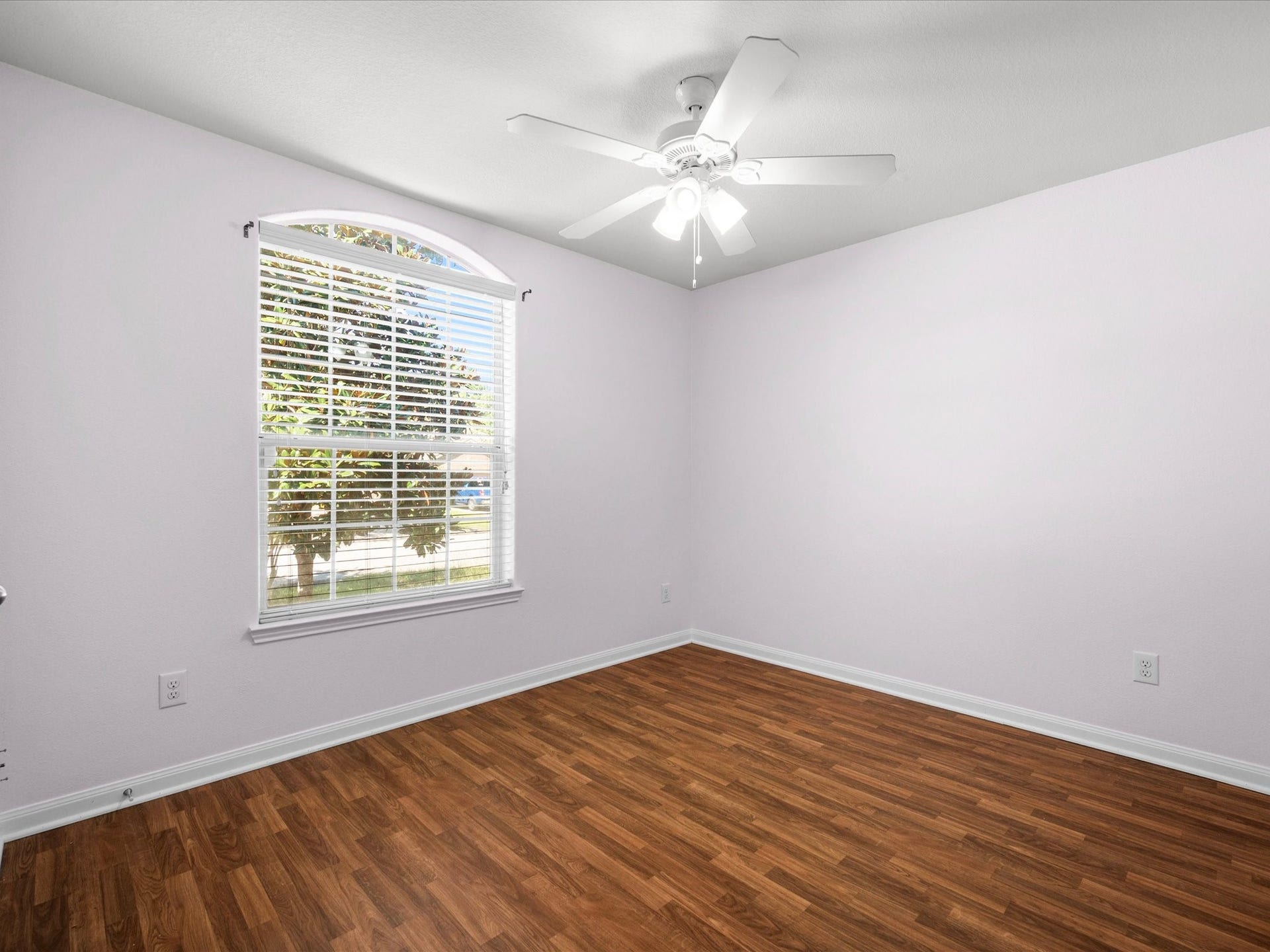 305 Pine Mist Lane, Conroe, TX 77304 This secondary bedroom features wood look flooring, a ceiling fan, and a charming arched window.