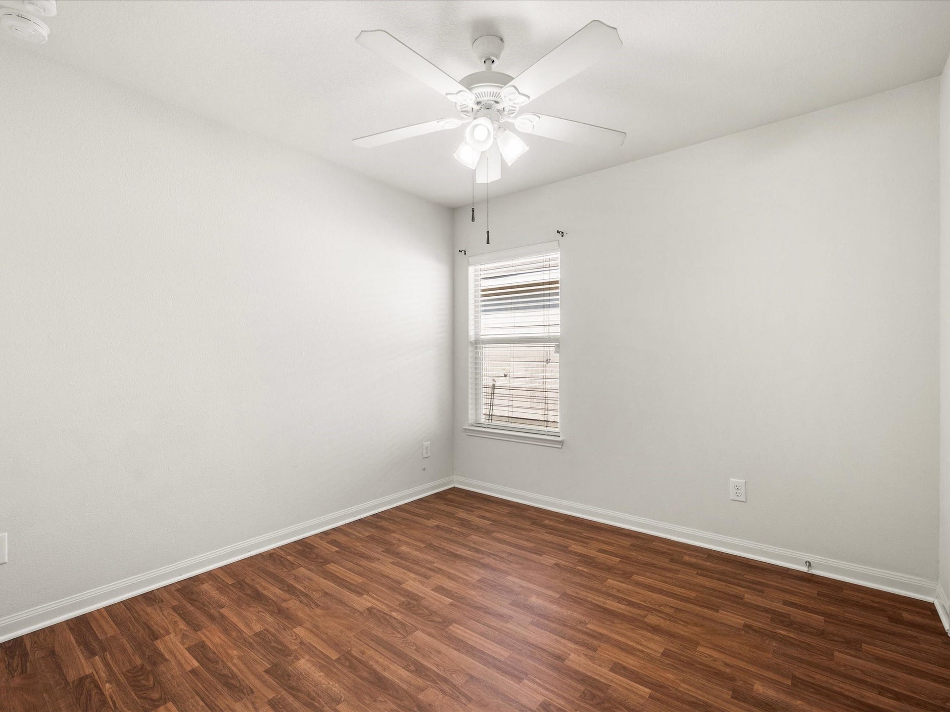 305 Pine Mist Lane, Conroe, TX 77304 A versatile secondary bedroom with neutral walls, wood look flooring, and a ceiling fan.
